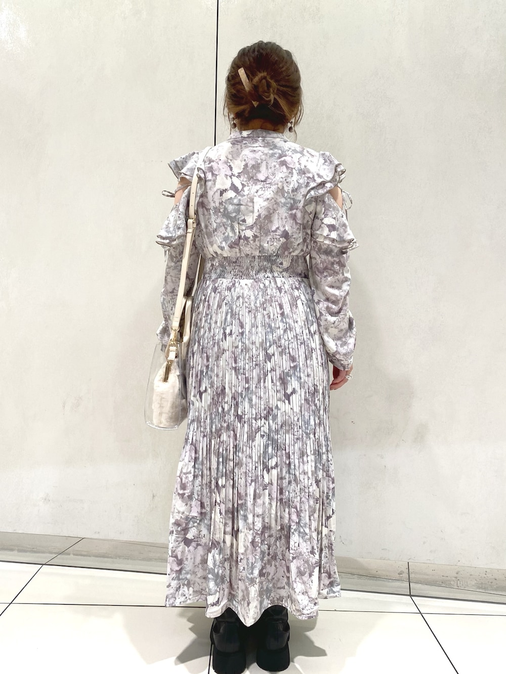 パープル系のワンピース、ブラック系のブーツ、ホワイト系のショルダーバッグを着用したレディースの秋コーディネートの3枚目の写真