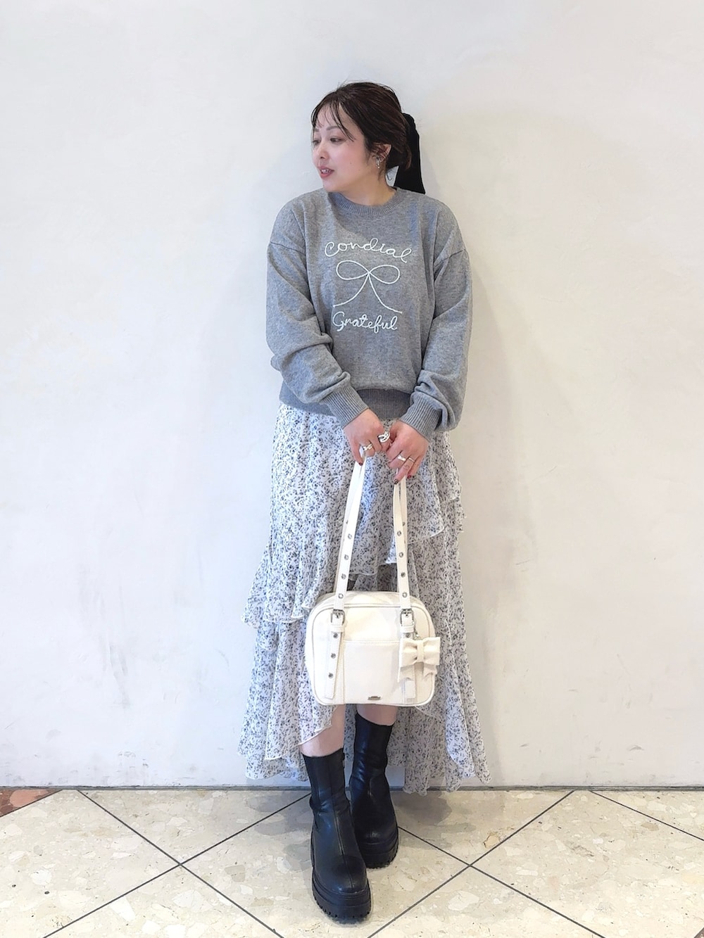 ホワイト系のダウンジャケット/コート、グレー系のニット/セーター、ホワイト系のワンピースを着用したレディースの冬コーディネートの3枚目の写真