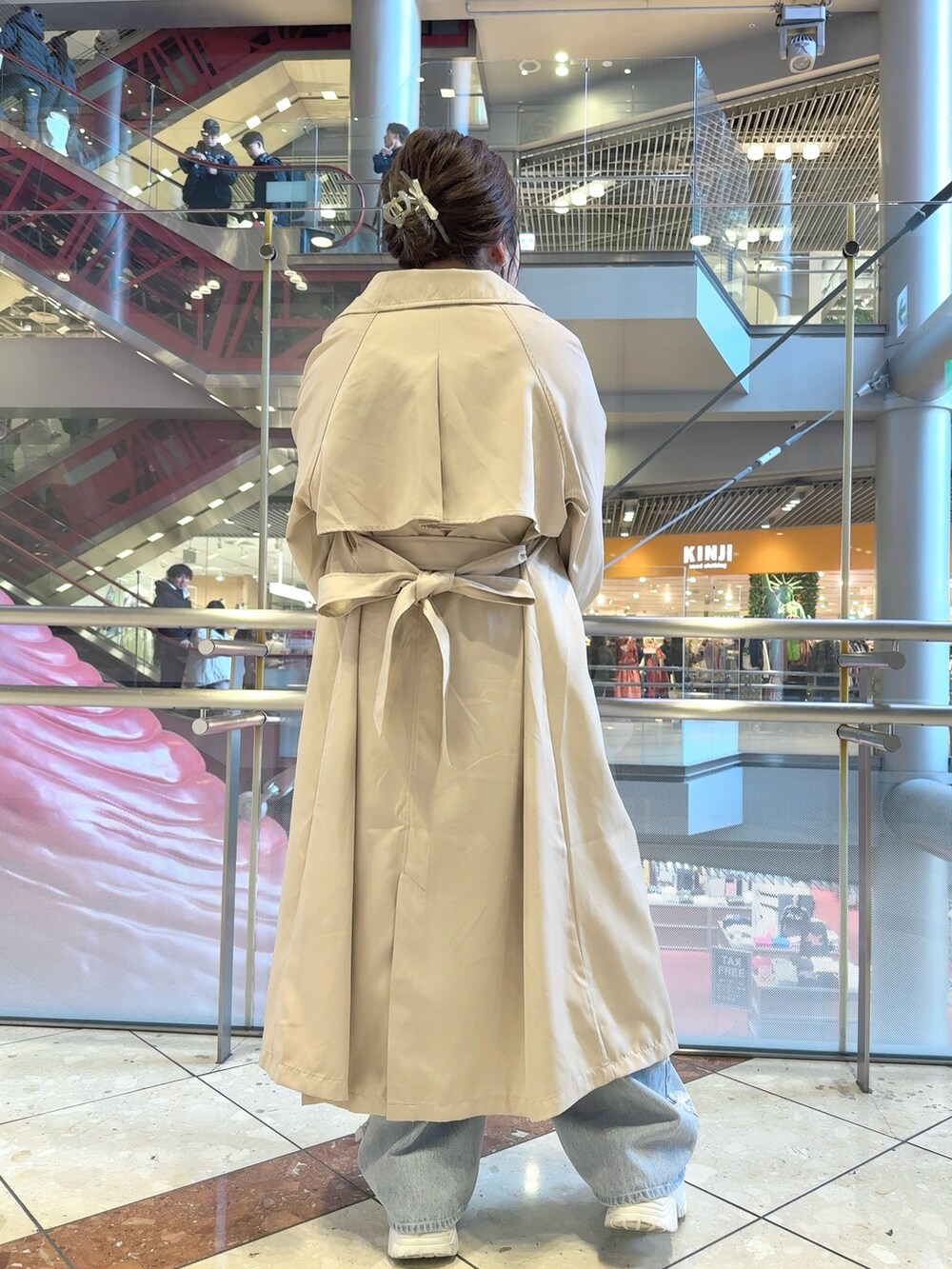 ベージュ系のトレンチコート、ピンク系のカーディガン/ボレロ、ホワイト系のショルダーバッグを着用したレディースの春コーディネートの4枚目の写真