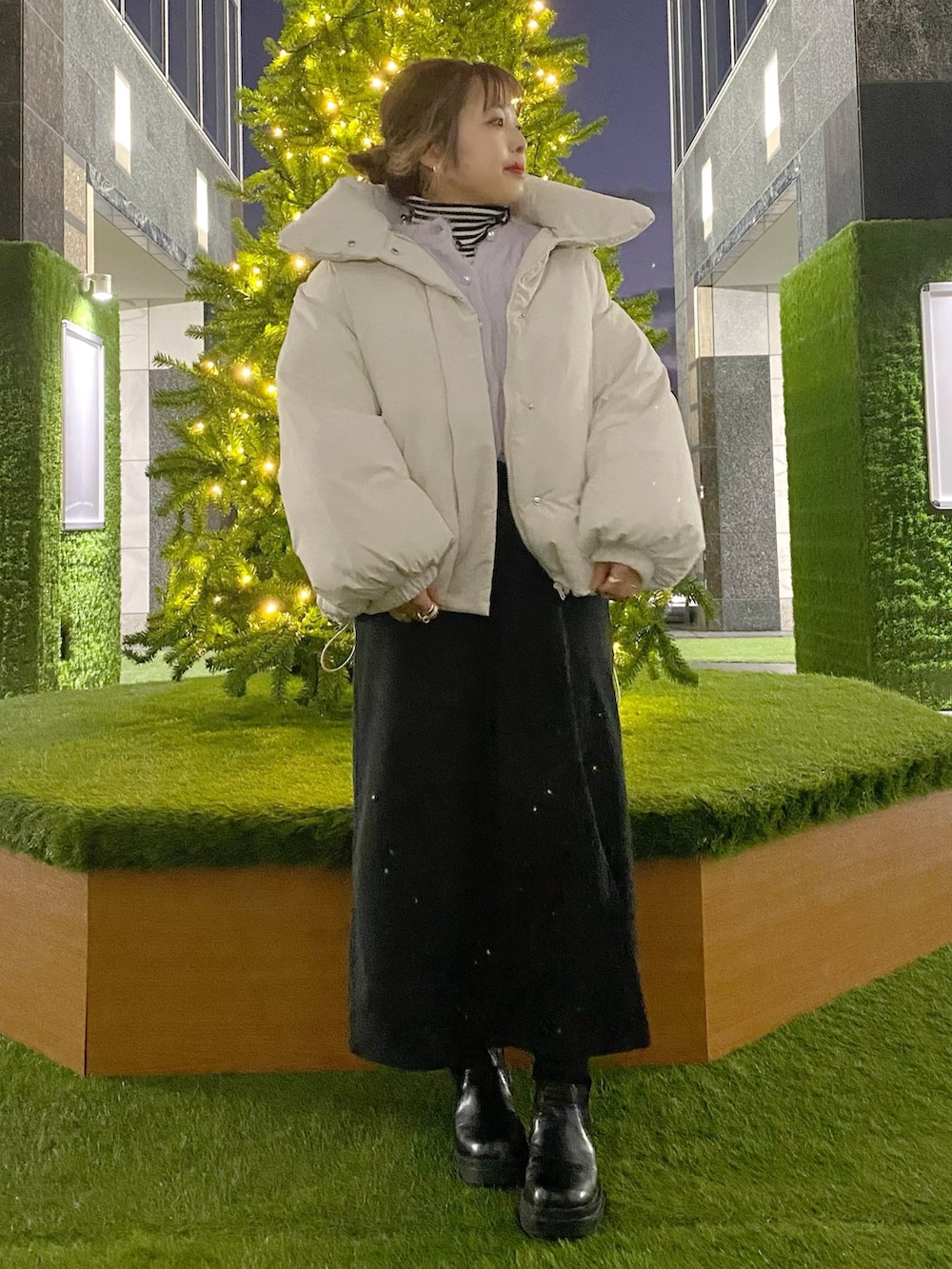 ホワイト系のダウンジャケット/コート、パープル系のカーディガン/ボレロ、ブラック系のニット/セーターを着用したレディースの冬コーディネートの2枚目の写真