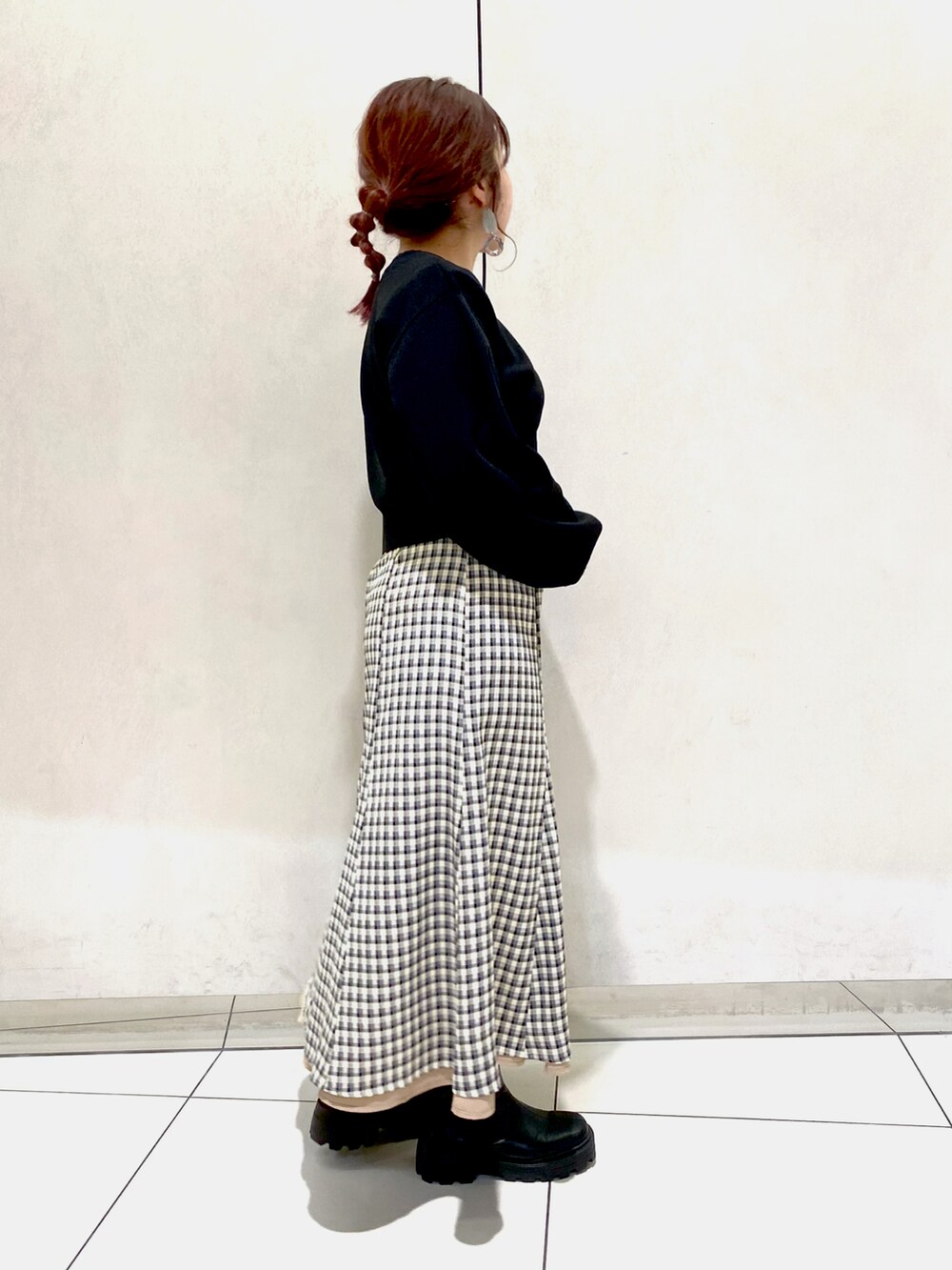 ベージュ系のスカート、ブラック系のブーツ、ブラウン系のショルダーバッグを着用したレディースの冬コーディネートの2枚目の写真