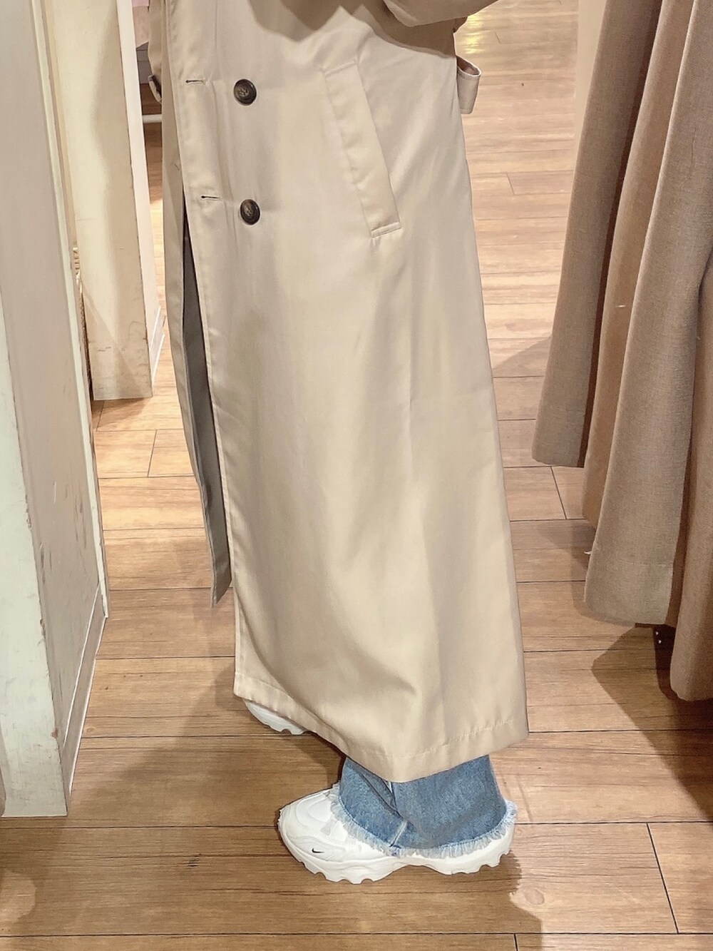 ベージュ系のトレンチコート、ブルー系のシャツ/ブラウス、ブルー系のデニムパンツを着用したレディースの冬コーディネートの2枚目の写真