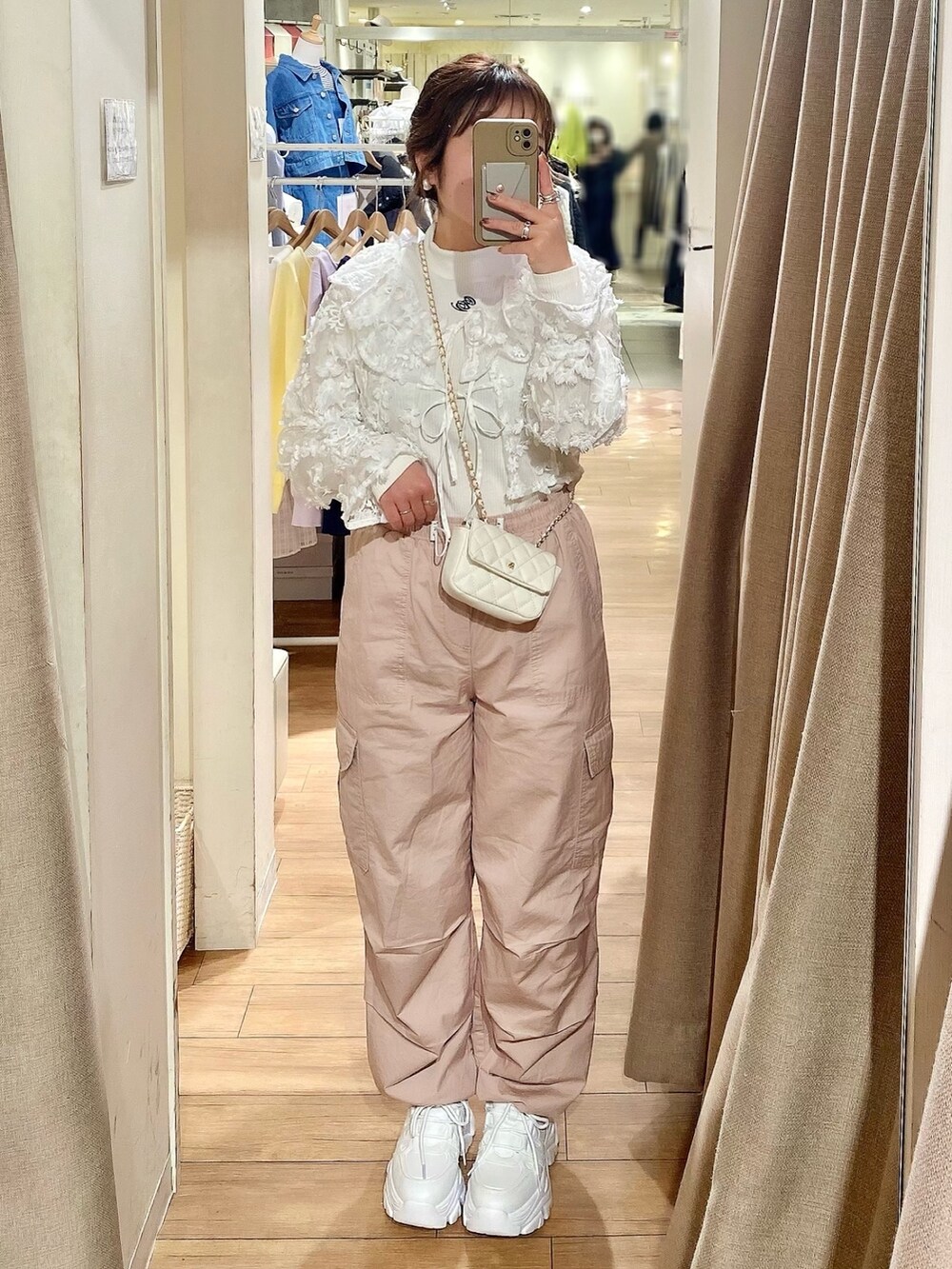 ベージュ系のトレンチコート、ピンク系のカーゴパンツ、ホワイト系のTシャツ/カットソーを着用したレディースの冬コーディネートの2枚目の写真