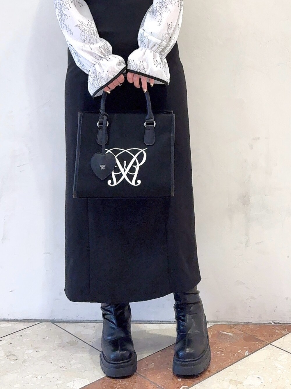 ホワイト系のドレス、ブラック系のトートバッグを着用したレディースの冬コーディネートの3枚目の写真