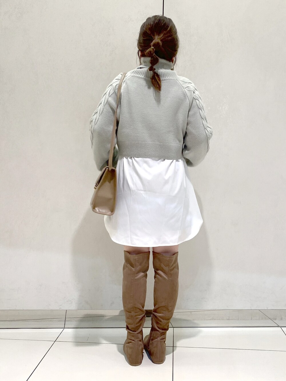 グリーン系のTシャツ/カットソー、ベージュ系のショルダーバッグ、ベージュ系のブーツを着用したレディースの冬コーディネートの3枚目の写真