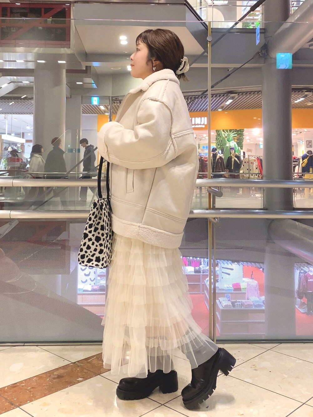 ホワイト系のムートンコート、その他のトートバッグ、ホワイト系のスカートを着用したレディースの秋コーディネートの3枚目の写真