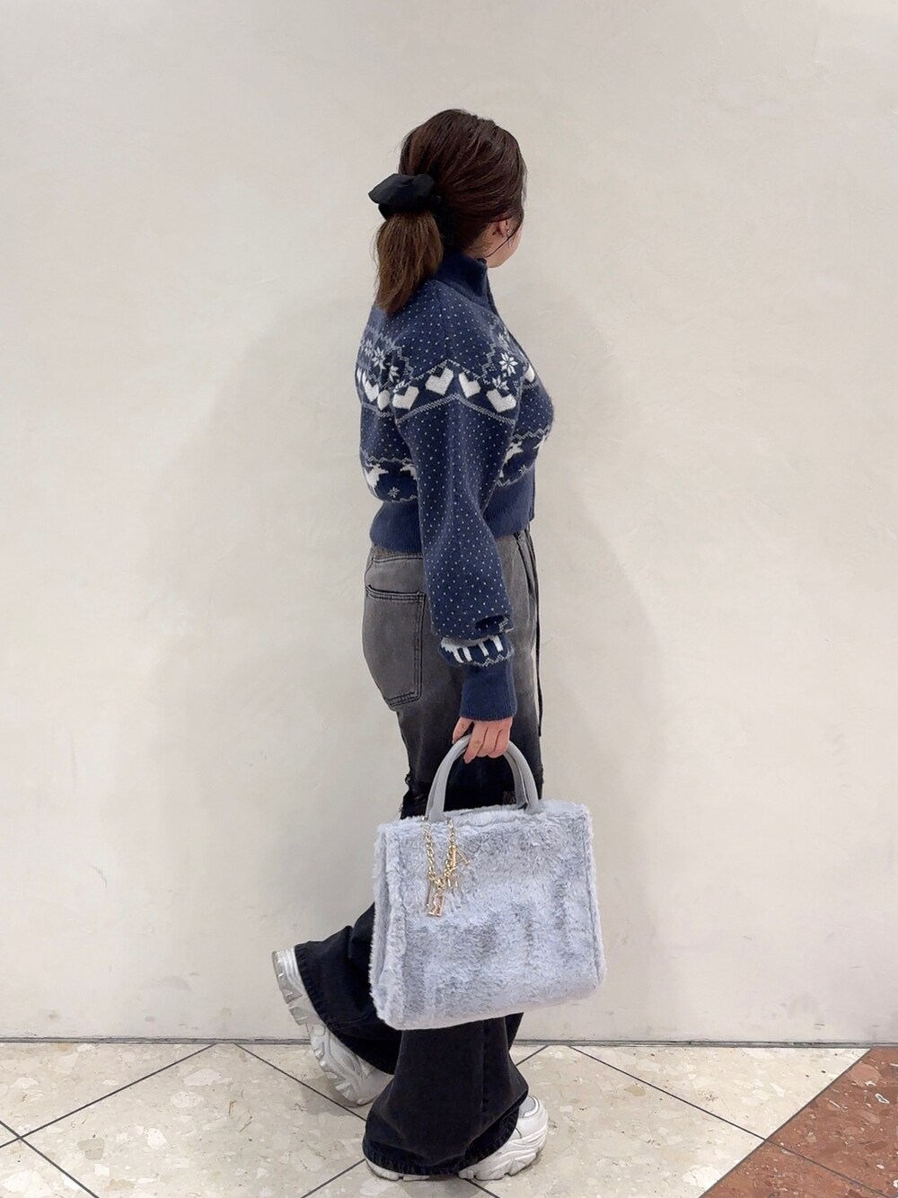 ブルー系のカーディガン/ボレロ、ブラック系のデニムパンツ、ホワイト系のスニーカーを着用したレディースの秋コーディネートの3枚目の写真