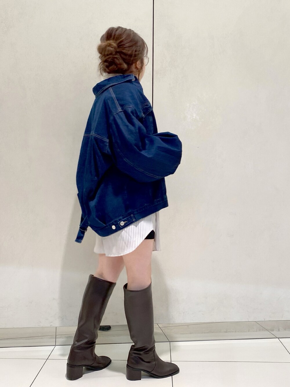 ブルー系のデニムジャケット、ホワイト系のTシャツ/カットソー、ブラウン系のブーツを着用したレディースの冬コーディネートの2枚目の写真