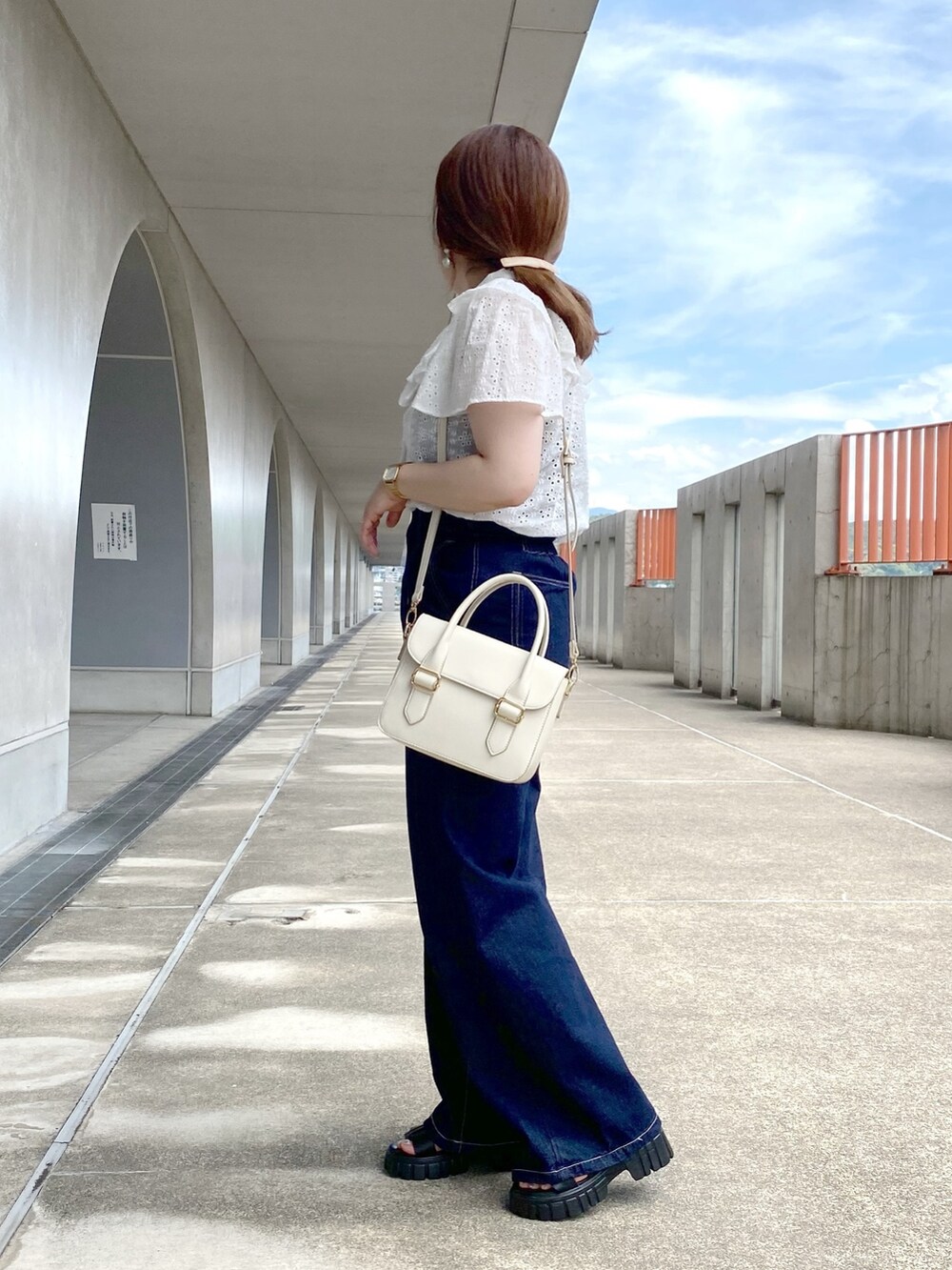 ホワイト系のシャツ/ブラウス、ブルー系のデニムパンツ、ホワイト系のショルダーバッグを着用したレディースの夏コーディネートの2枚目の写真