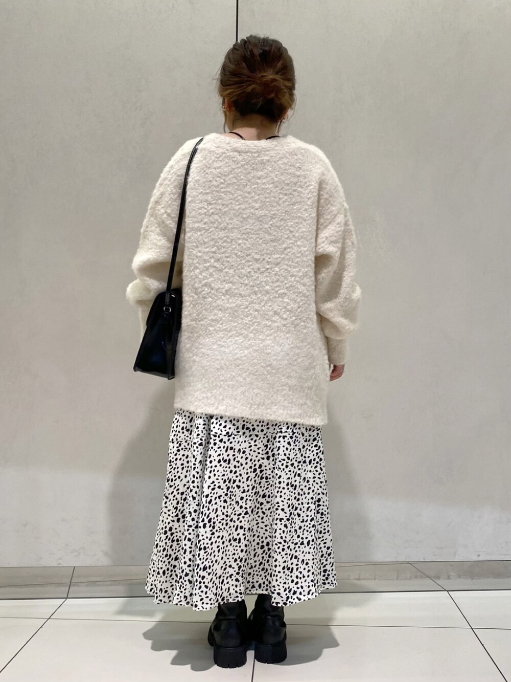 ホワイト系のカーディガン/ボレロ、ホワイト系のスカート、ブラック系のブーツを着用したレディースの秋コーディネートの3枚目の写真