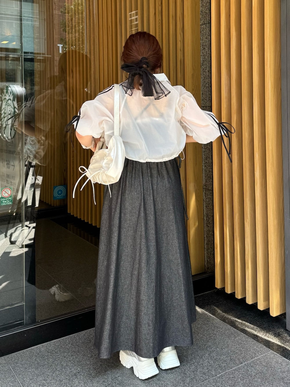 ホワイト系のブルゾン、ブラック系のワンピース、シルバー系のショルダーバッグを着用したレディースの夏コーディネートの3枚目の写真