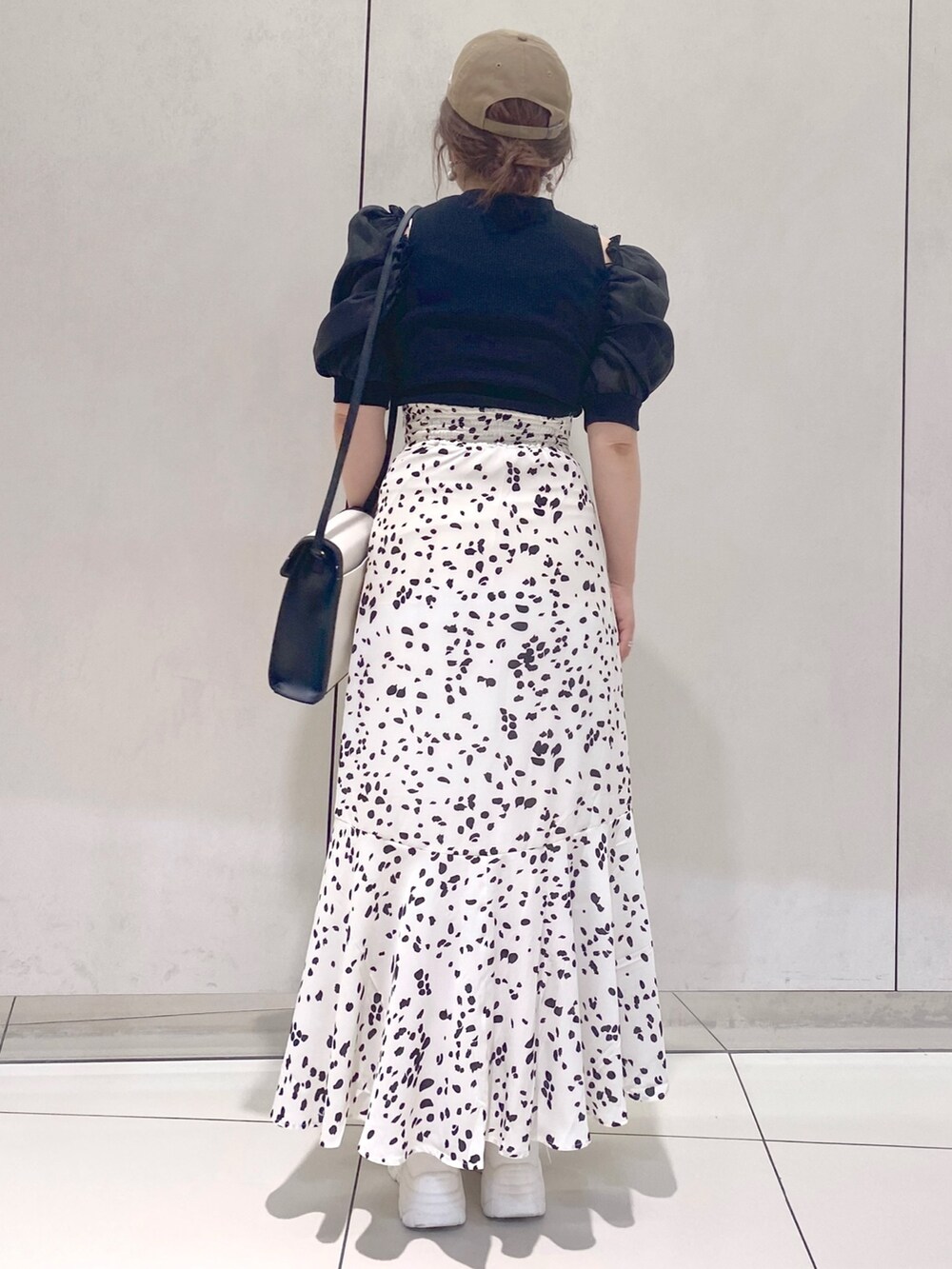 ホワイト系のスカート、ブラック系のTシャツ/カットソー、ブラック系のショルダーバッグを着用したレディースの夏コーディネートの4枚目の写真