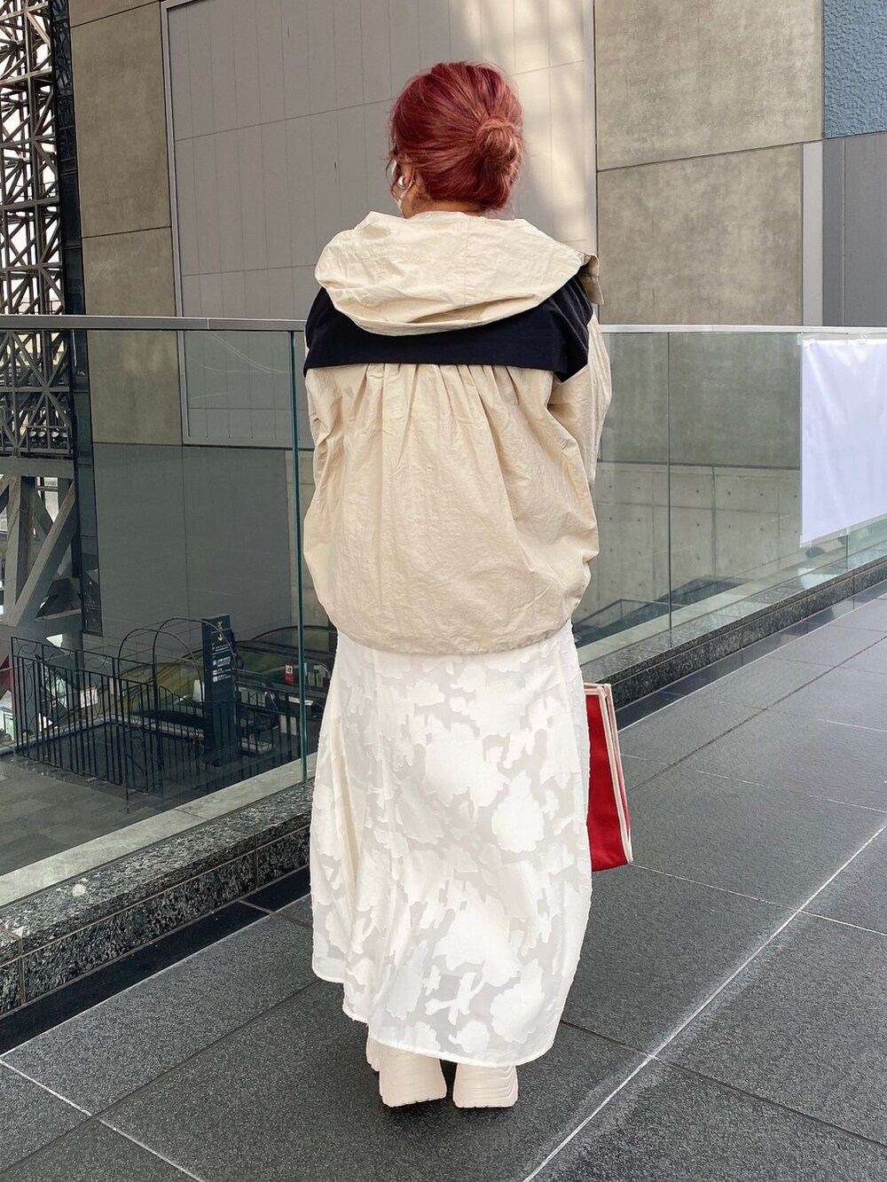 ホワイト系のスカート、ベージュ系のマウンテンパーカー、ホワイト系のニット/セーターを着用したレディースの春コーディネートの4枚目の写真