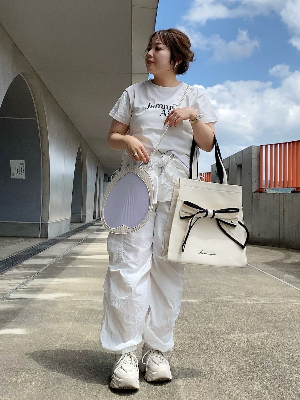 ホワイト系のTシャツ/カットソー、ホワイト系のつなぎ/オールインワン、ブラック系のトートバッグを着用したレディースの夏コーディネートの2枚目の写真