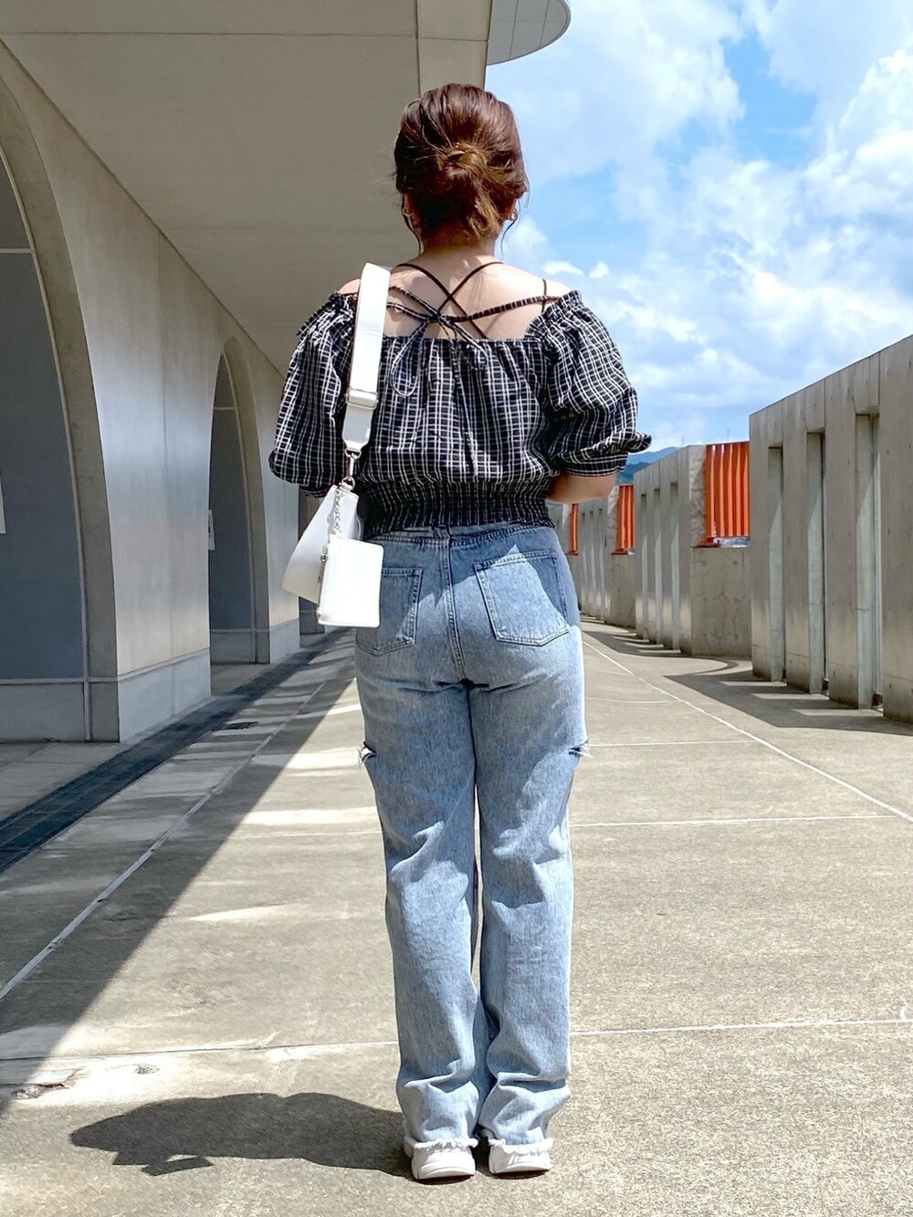 ブラック系のシャツ/ブラウス、ブルー系のデニムパンツ、ベージュ系のスニーカーを着用したレディースの夏コーディネートの3枚目の写真