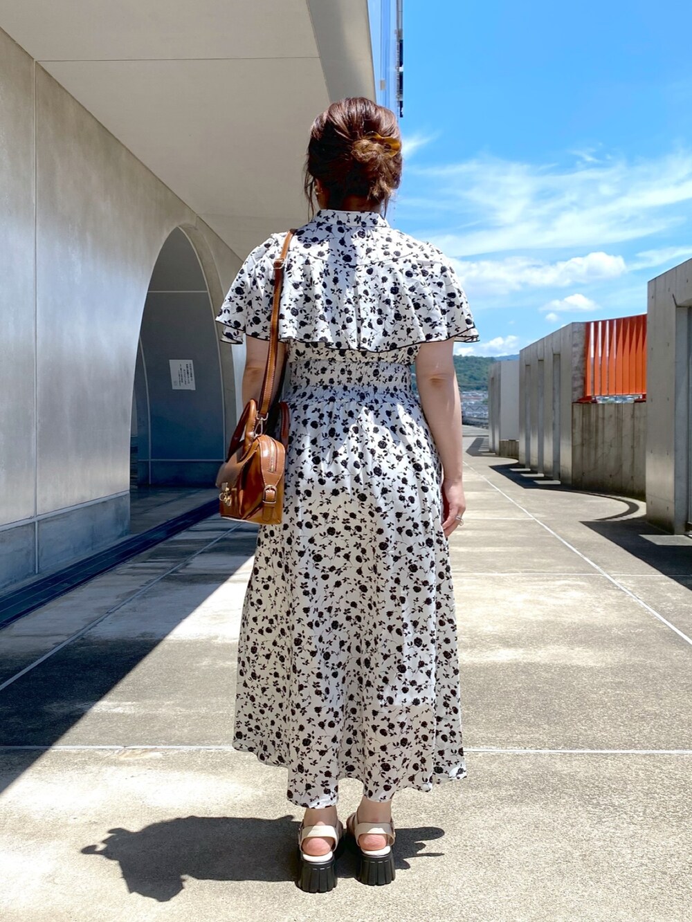 ホワイト系のワンピース、ホワイト系のサンダル、イエロー系のショルダーバッグを着用したレディースの夏コーディネートの3枚目の写真