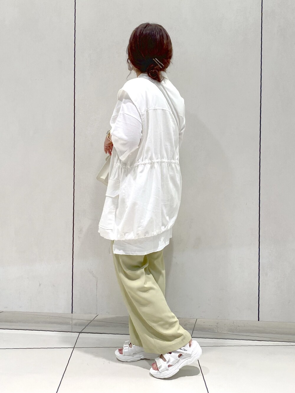 グリーン系のスラックス、ホワイト系のTシャツ/カットソー、ホワイト系のその他アウターを着用したレディースの春コーディネートの3枚目の写真