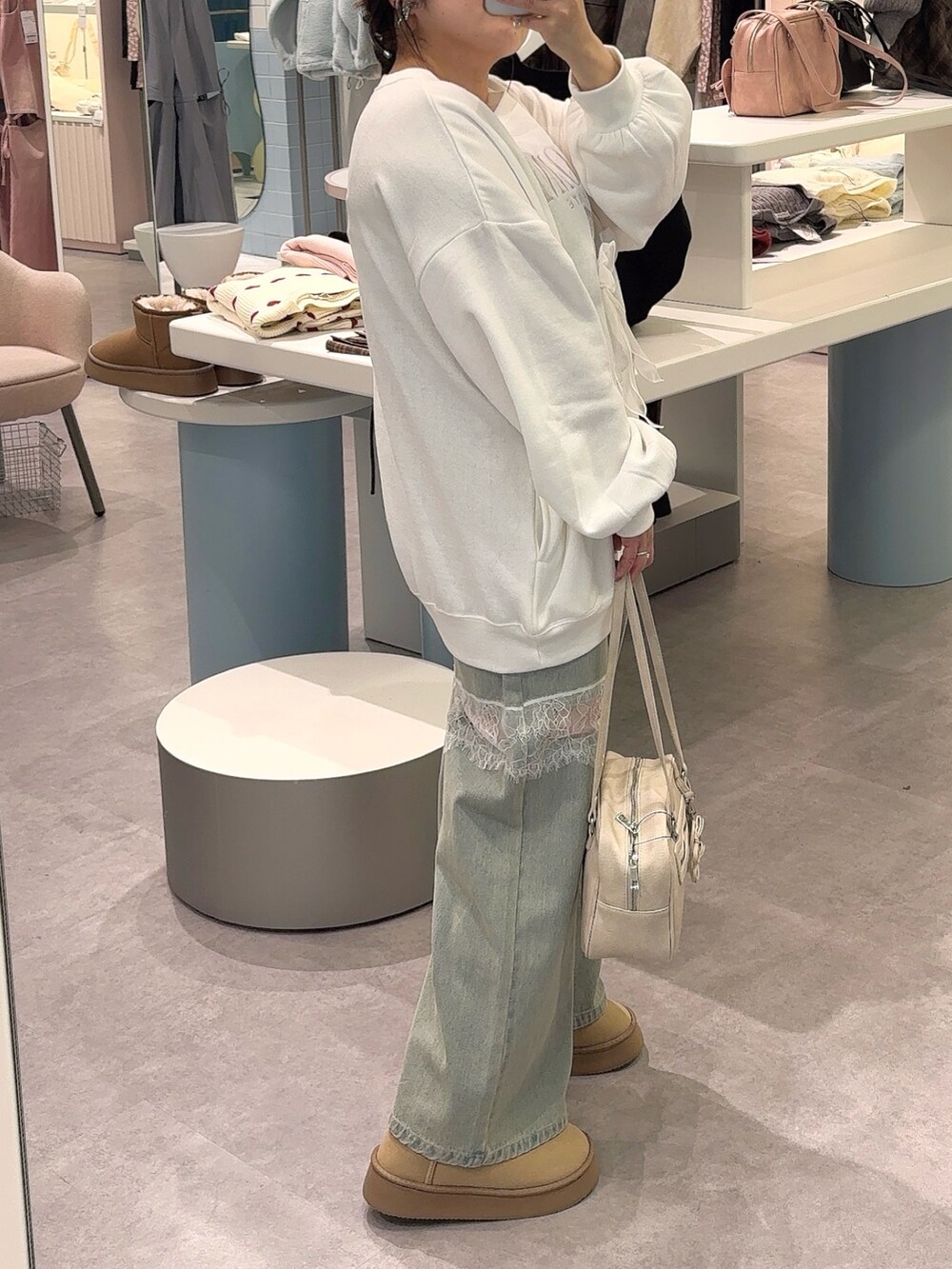 ホワイト系のTシャツ/カットソー、ブルー系のデニムパンツ、ベージュ系のブーツを着用したレディースの秋コーディネートの3枚目の写真