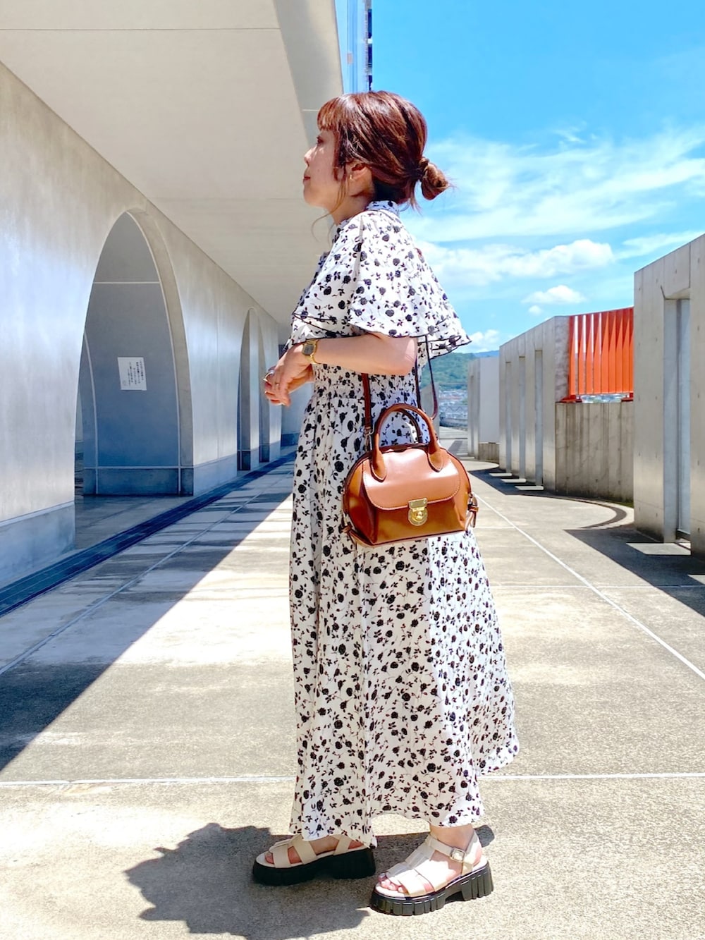 ホワイト系のワンピース、ホワイト系のサンダル、イエロー系のショルダーバッグを着用したレディースの夏コーディネートの2枚目の写真