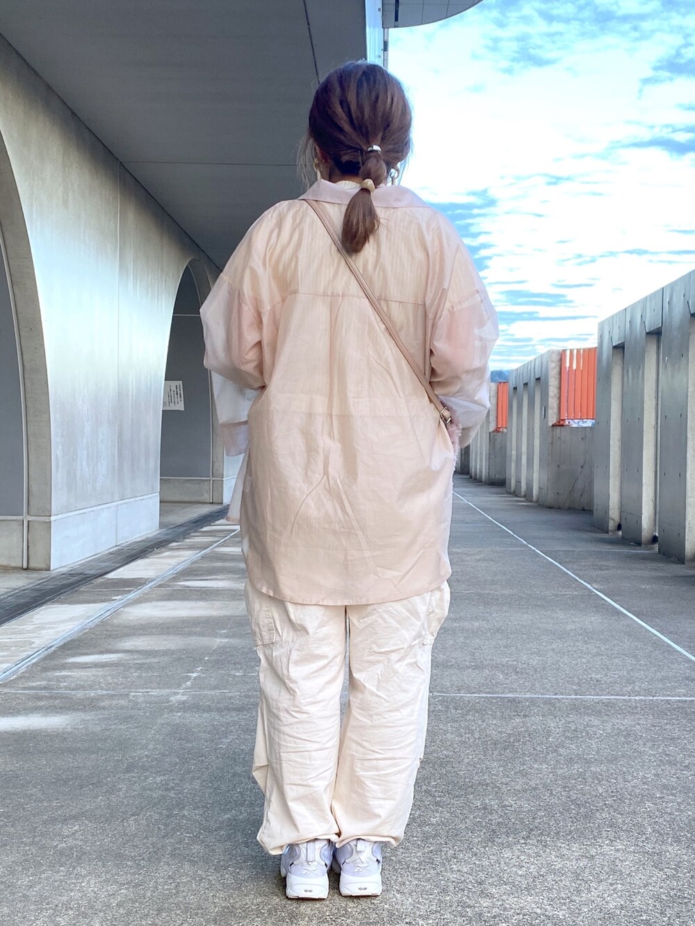 ホワイト系のニット/セーター、ベージュ系のシャツ/ブラウス、ホワイト系のカーゴパンツを着用したレディースの秋コーディネートの4枚目の写真