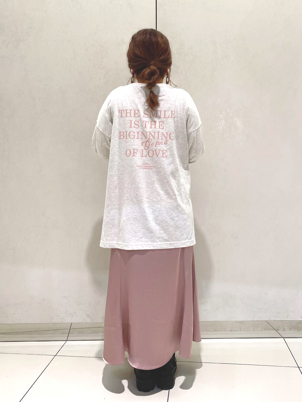 ピンク系のスカート、ブラック系のブーツ、グレー系のTシャツ/カットソーを着用したレディースの冬コーディネートの3枚目の写真