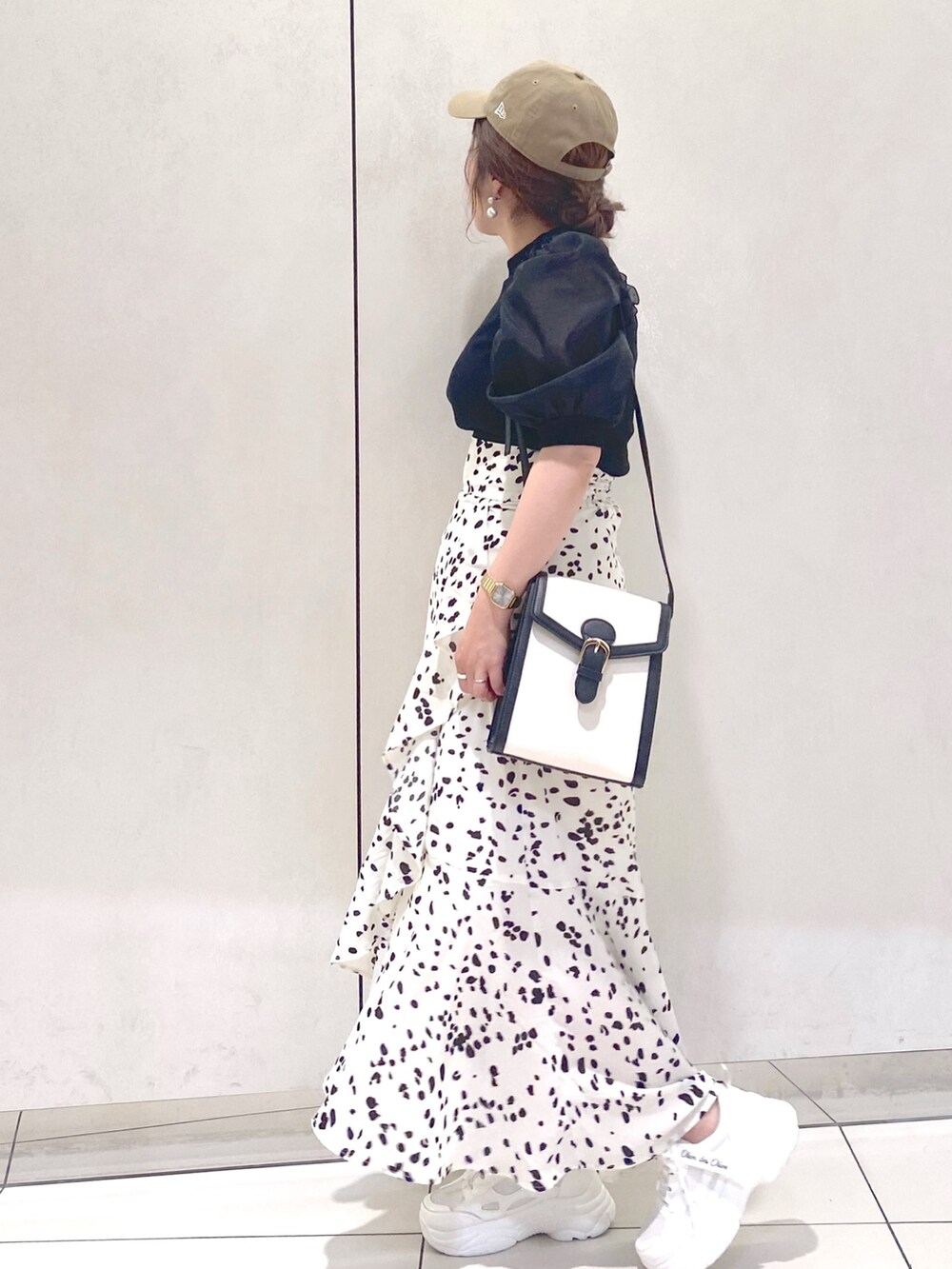 ホワイト系のスカート、ブラック系のTシャツ/カットソー、ブラック系のショルダーバッグを着用したレディースの夏コーディネートの3枚目の写真