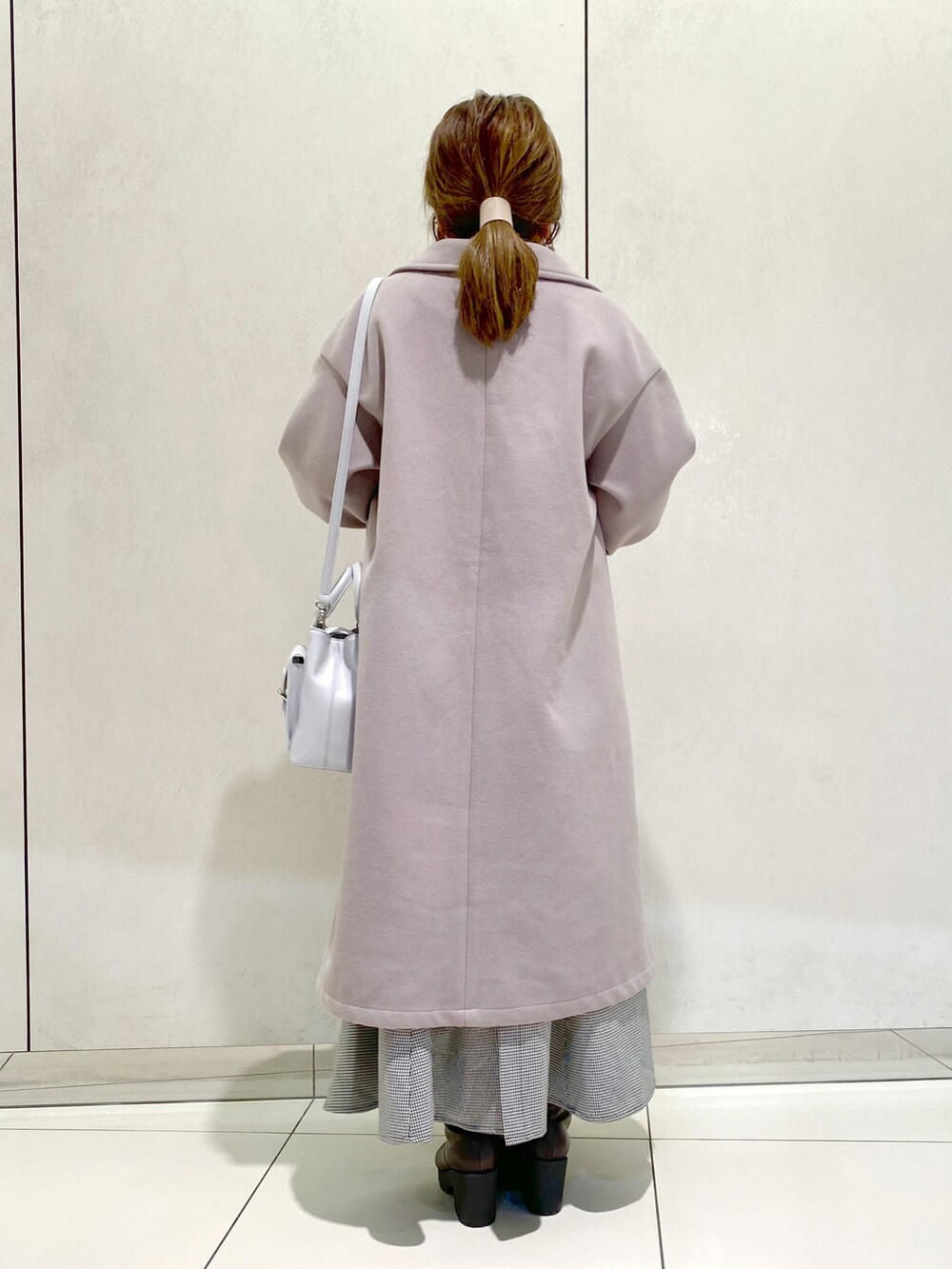 グレー系のベスト、ホワイト系のTシャツ/カットソー、ブラウン系のチェスターコートを着用したレディースの冬コーディネートの3枚目の写真