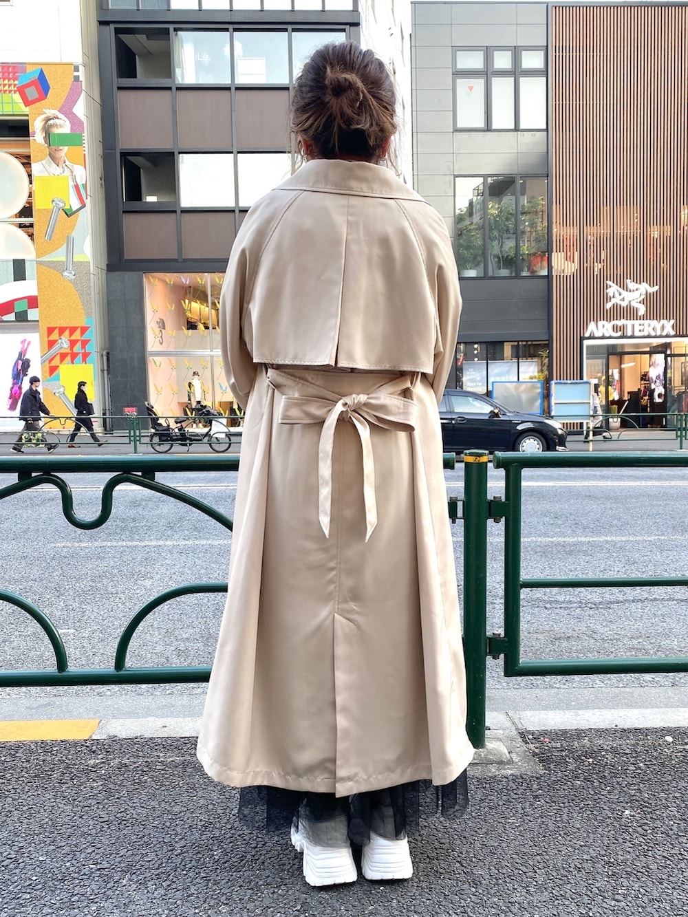 ベージュ系のトレンチコート、ホワイト系のTシャツ/カットソー、ブラック系のスカートを着用したレディースの春コーディネートの4枚目の写真