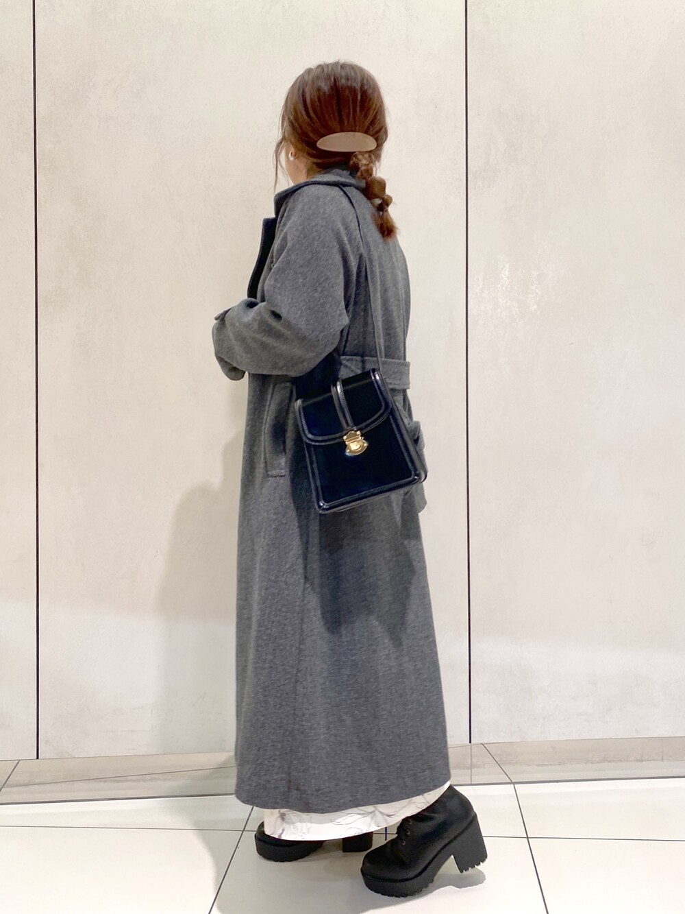 ホワイト系のワンピース、ブラック系のブーツ、ブラック系のショルダーバッグを着用したレディースの秋コーディネートの2枚目の写真