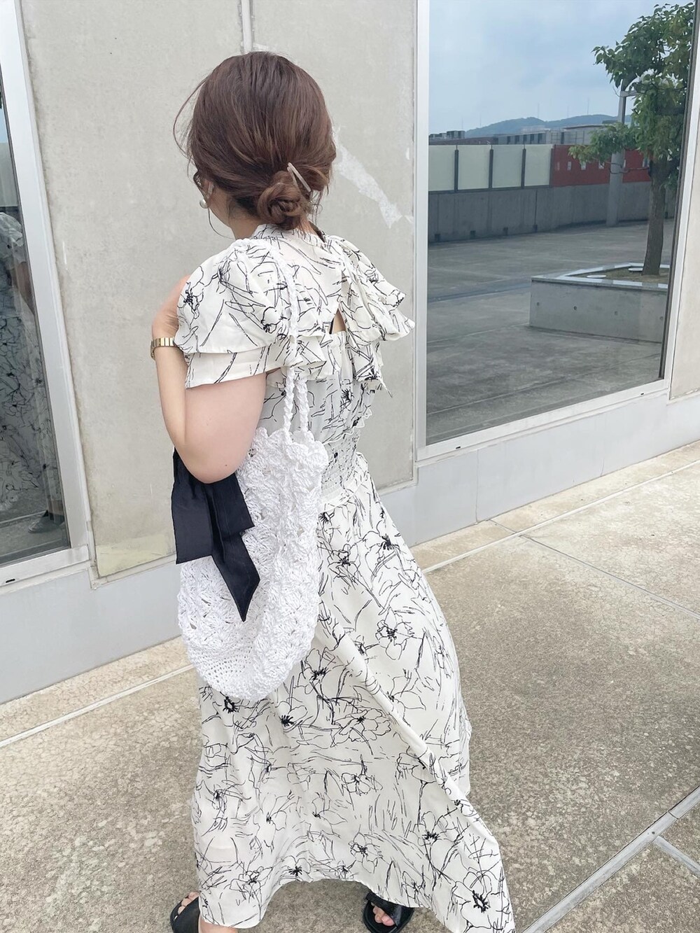 ホワイト系のワンピース、ホワイト系のかごバッグ、ブラック系のサンダルを着用したレディースの夏コーディネートの4枚目の写真