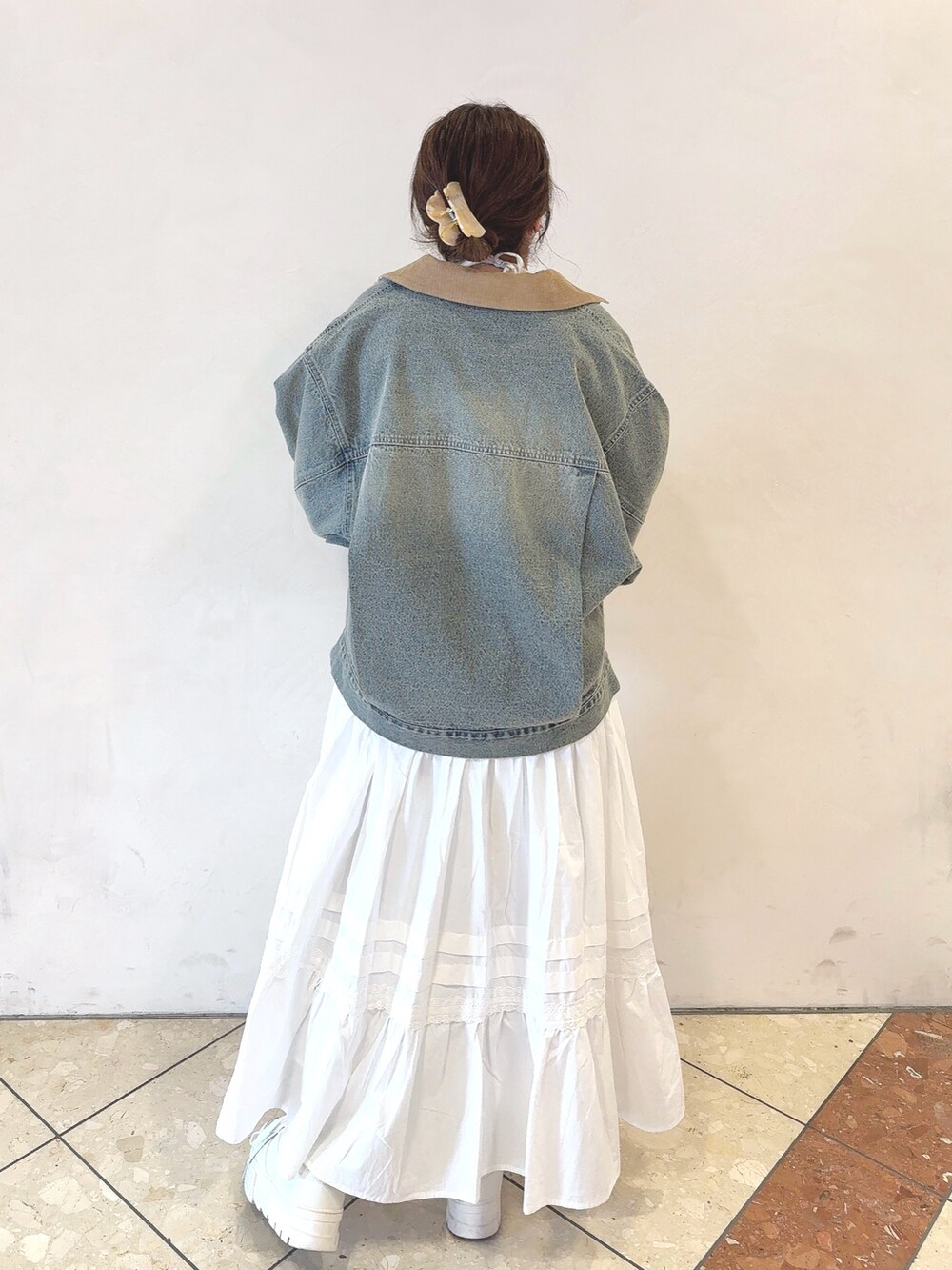 ブルー系のデニムジャケット、ホワイト系のTシャツ/カットソー、ブラウン系のショルダーバッグを着用したレディースの冬コーディネートの4枚目の写真