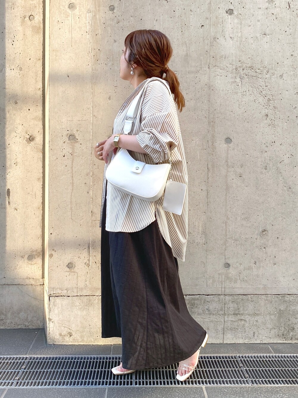 ブラウン系のシャツ/ブラウス、ホワイト系のサンダル、ブラック系のワンピースを着用したレディースの夏コーディネートの2枚目の写真