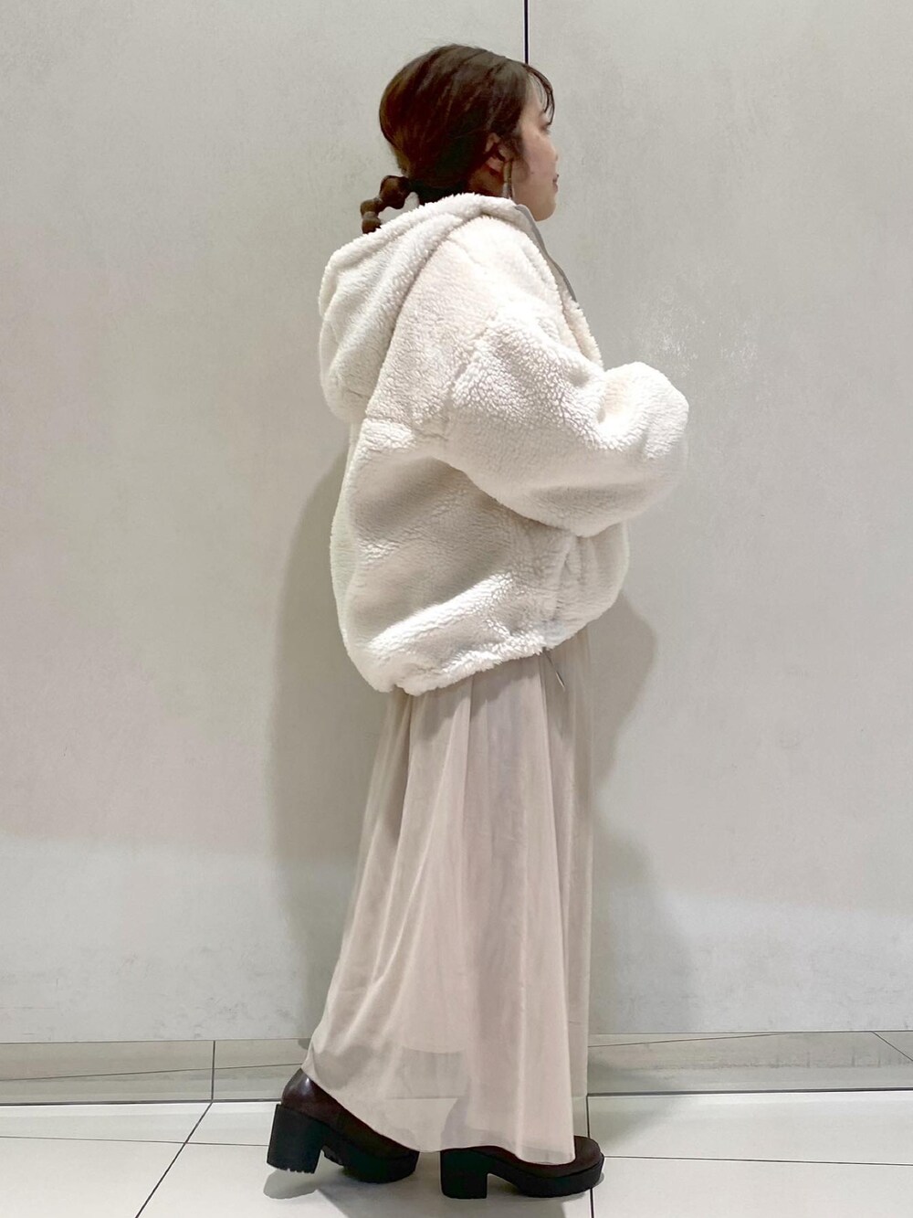 グレー系のブルゾン、ブラウン系のワンピース、ブラウン系のブーツを着用したレディースの秋コーディネートの2枚目の写真