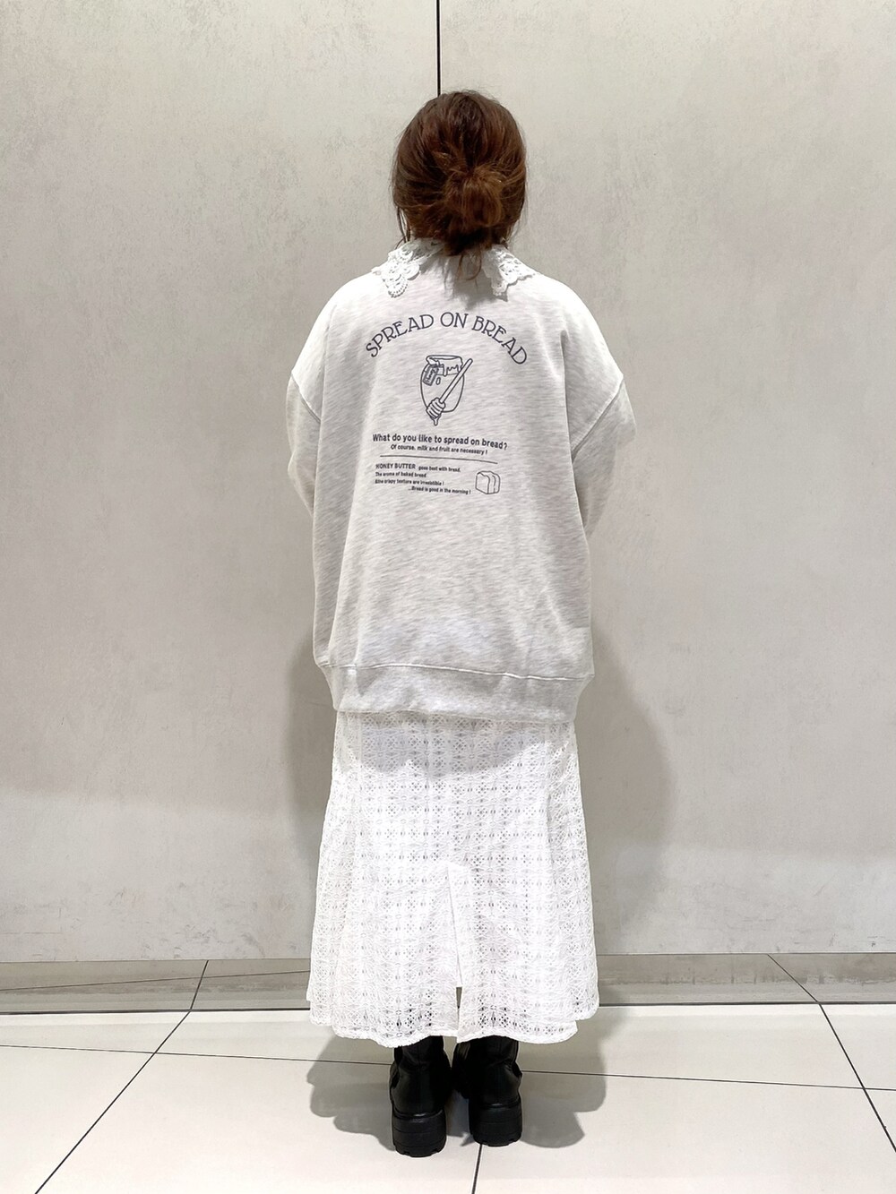 グレー系のスウェット、ホワイト系のシャツ/ブラウス、ホワイト系のスカートを着用したレディースの冬コーディネートの2枚目の写真