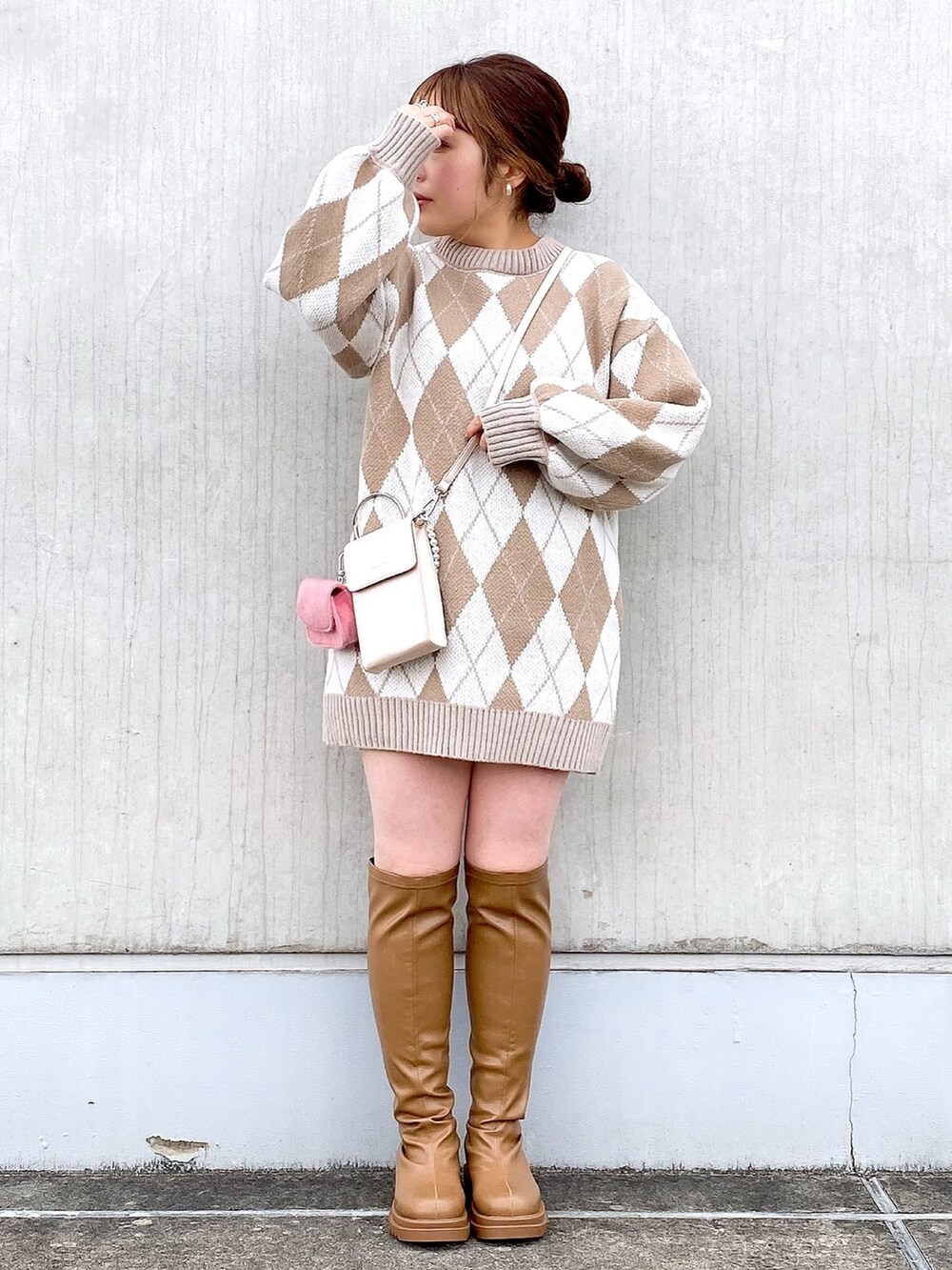 ベージュ系のニット/セーター、ピンク系のショルダーバッグ、イエロー系のブーツを着用したレディースの冬コーディネートの2枚目の写真