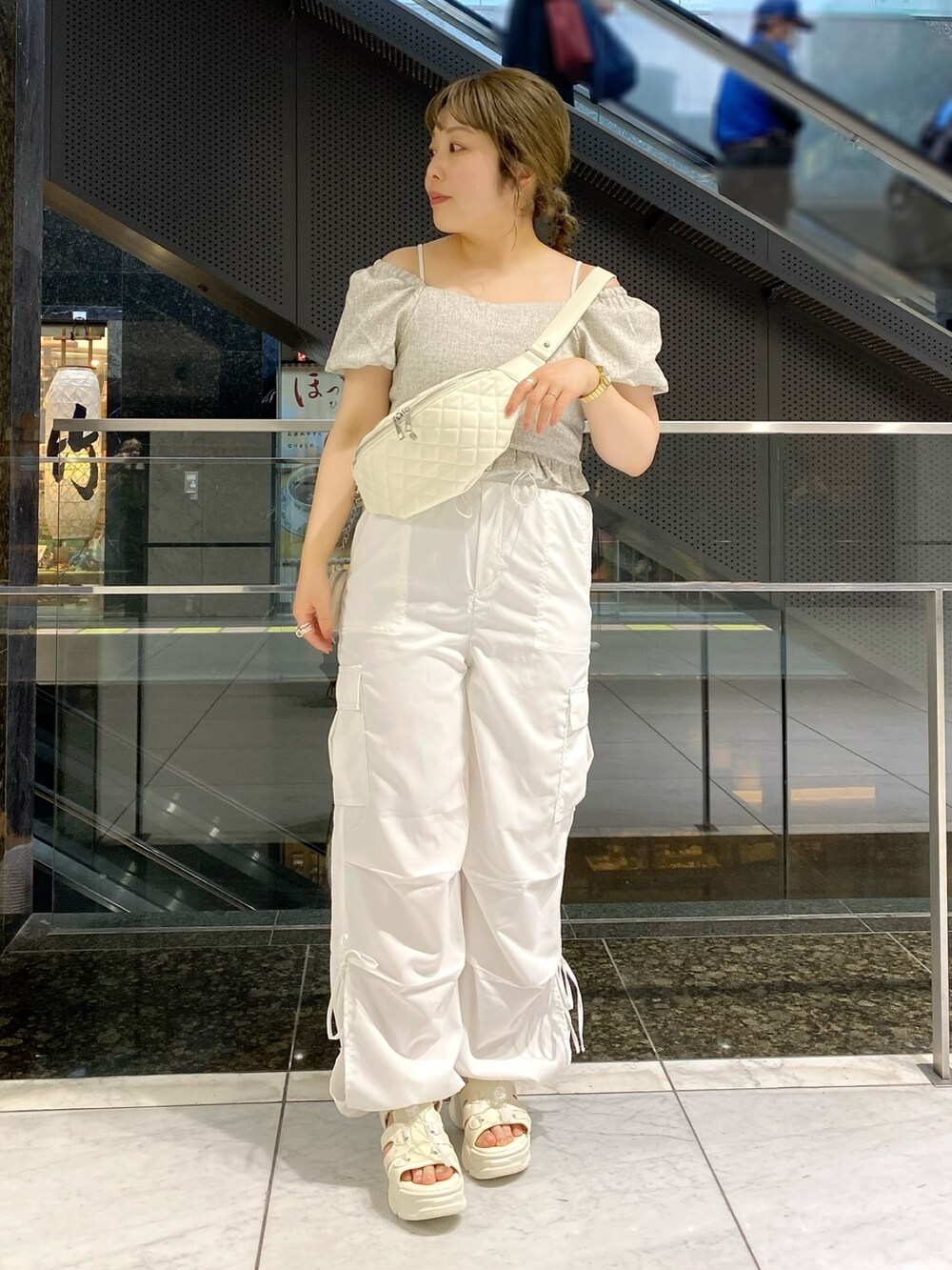 ホワイト系のシャツ/ブラウス、ホワイト系のカーゴパンツ、ホワイト系のサンダルを着用したレディースの春コーディネートの2枚目の写真