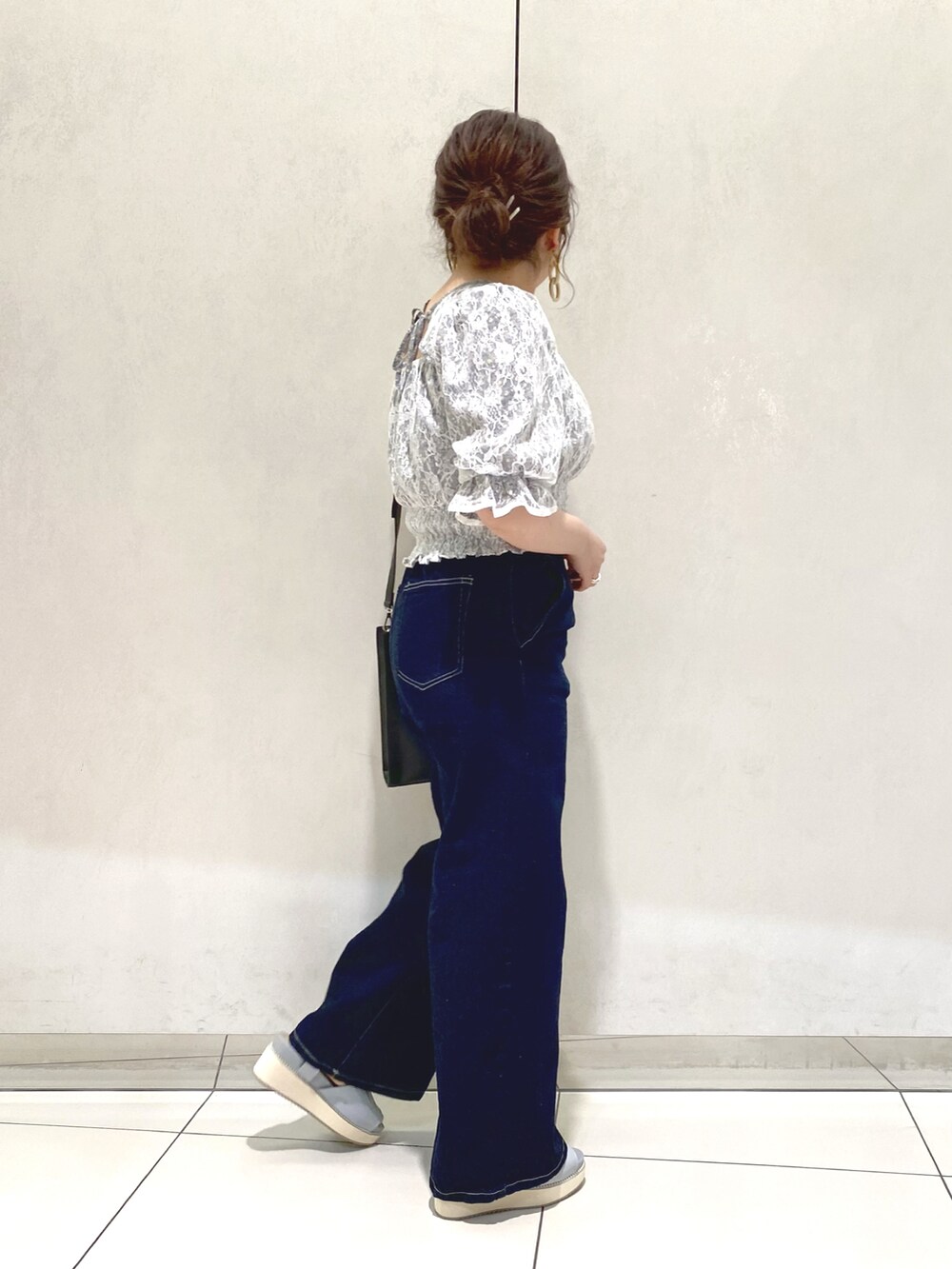 ブルー系のシャツ/ブラウス、ブラック系のショルダーバッグ、ブルー系のデニムパンツを着用したレディースの春コーディネートの2枚目の写真