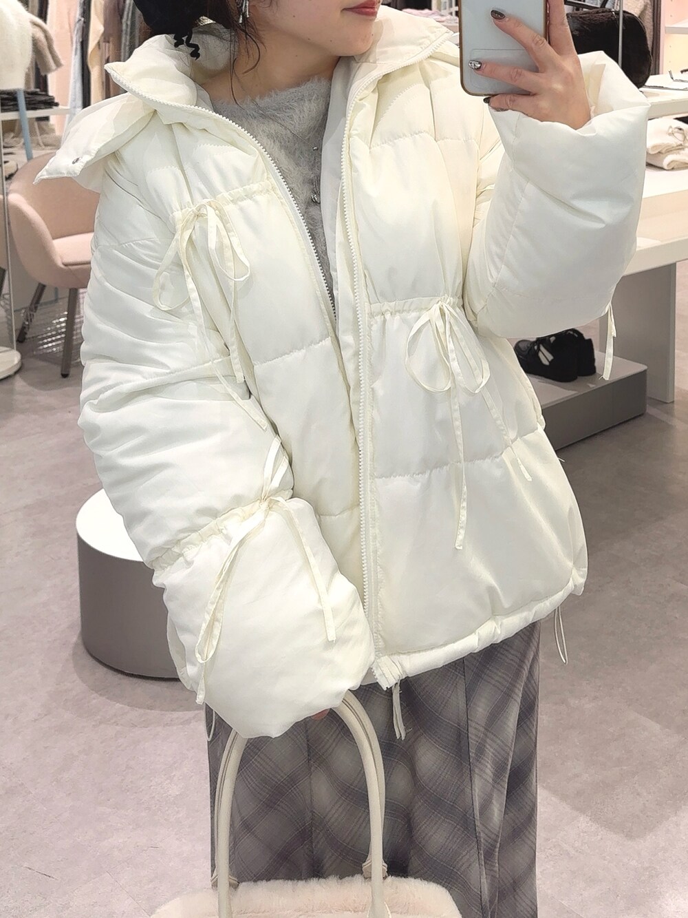 ホワイト系のダウンジャケット/コート、グレー系のワンピース、ホワイト系のショルダーバッグを着用したレディースの冬コーディネートの2枚目の写真