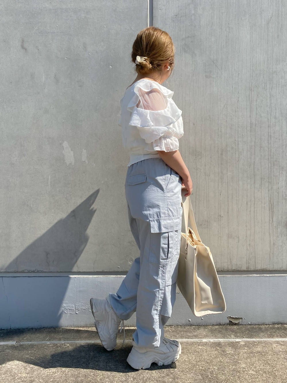 ホワイト系のシャツ/ブラウス、ブルー系のカーゴパンツ、ホワイト系のトートバッグを着用したレディースの春コーディネートの2枚目の写真