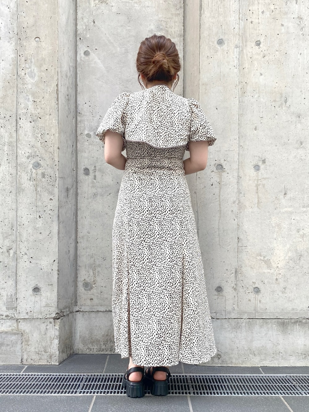 イエロー系のショルダーバッグ、ホワイト系のワンピース、ブラック系のサンダルを着用したレディースの夏コーディネートの3枚目の写真