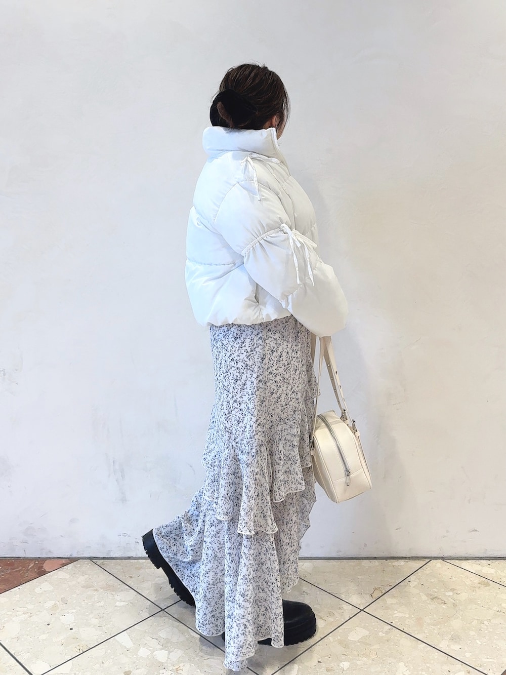 ホワイト系のダウンジャケット/コート、グレー系のニット/セーター、ホワイト系のワンピースを着用したレディースの冬コーディネートの2枚目の写真