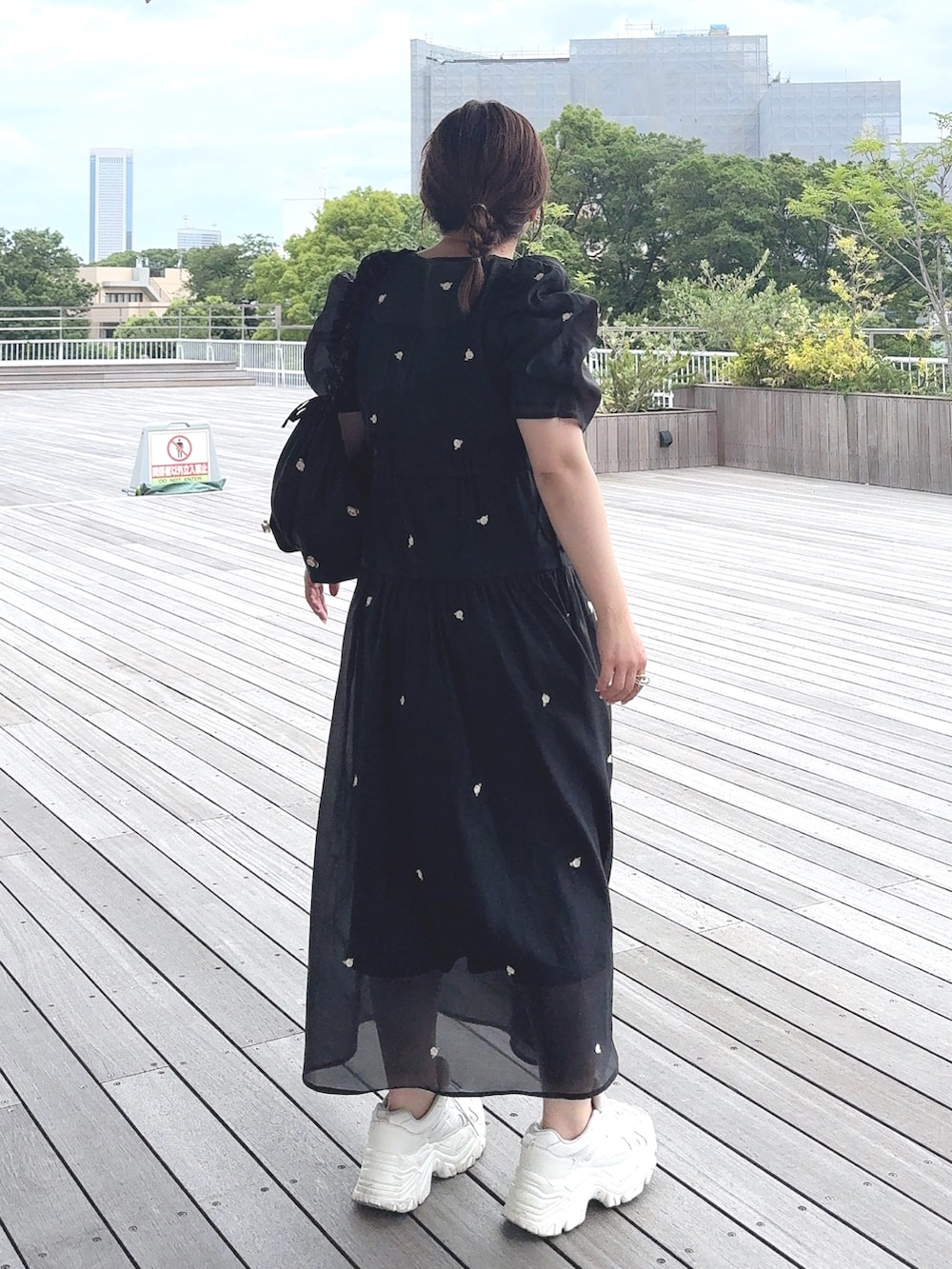 ブラック系のワンピース、ブラック系のショルダーバッグ、ホワイト系のスニーカーを着用したレディースの夏コーディネートの4枚目の写真