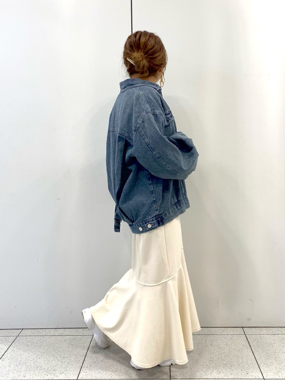 ホワイト系のスカート、ホワイト系のスニーカー、ブルー系のデニムジャケットを着用したレディースの春コーディネートの5枚目の写真