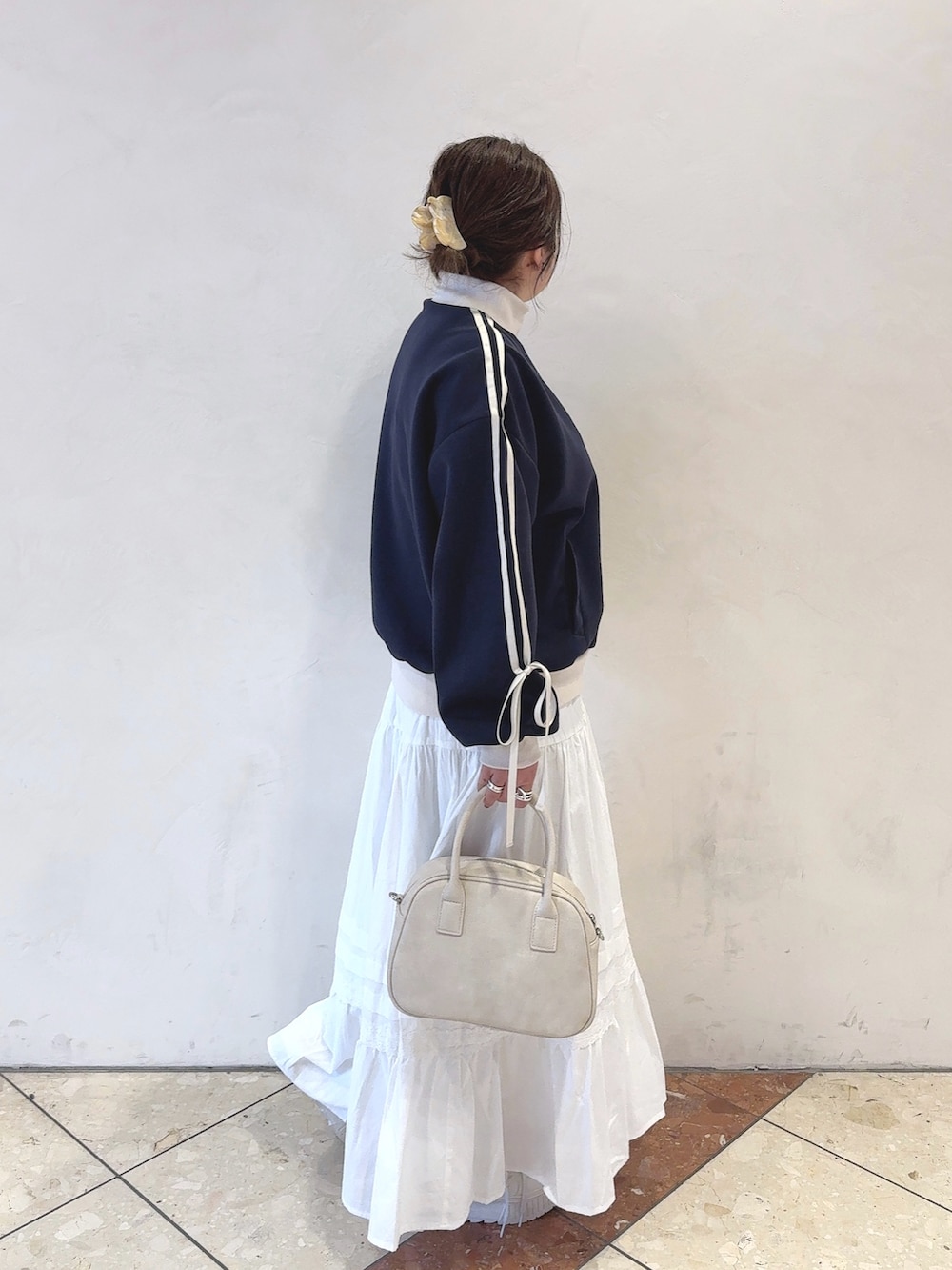 ブルー系のカーディガン/ボレロ、ホワイト系のスカート、ホワイト系のショルダーバッグを着用したレディースの冬コーディネートの3枚目の写真