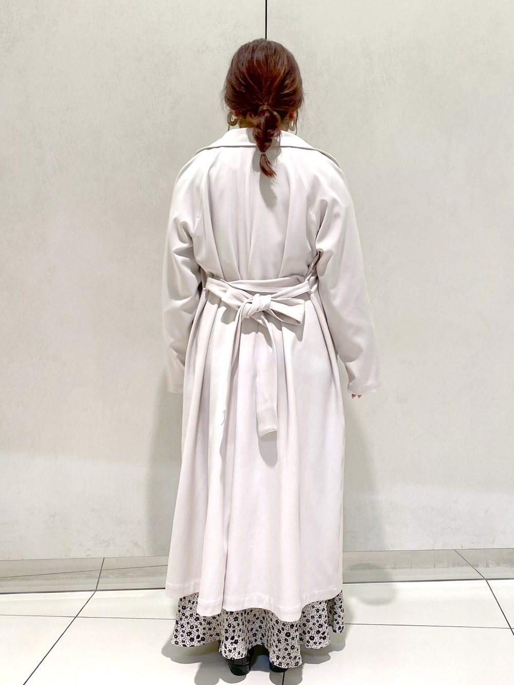 ホワイト系のトレンチコート、ホワイト系のワンピース、ブラック系のバレエシューズを着用したレディースの春コーディネートの3枚目の写真