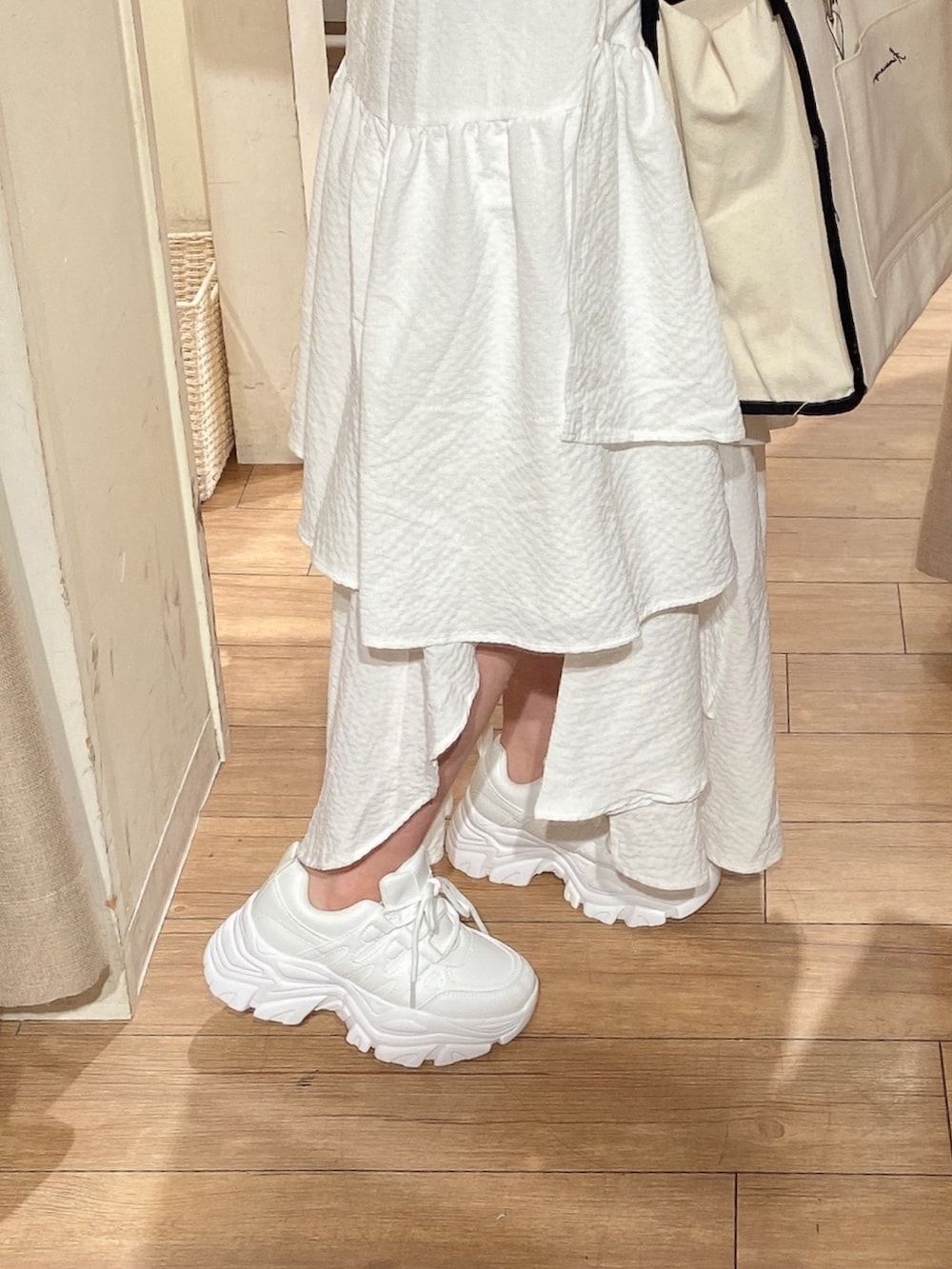 ホワイト系のシャツ/ブラウス、ホワイト系のTシャツ/カットソー、ブラック系のトートバッグを着用したレディースの春コーディネートの4枚目の写真