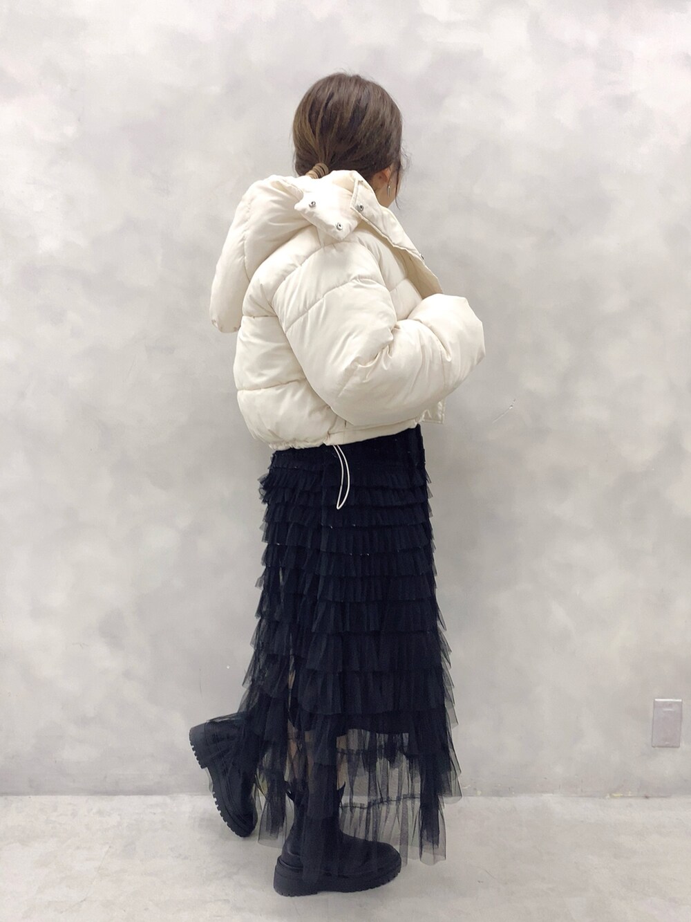 ホワイト系のダウンジャケット/コート、ホワイト系のニット/セーター、ブラック系のスカートを着用したレディースの冬コーディネートの3枚目の写真