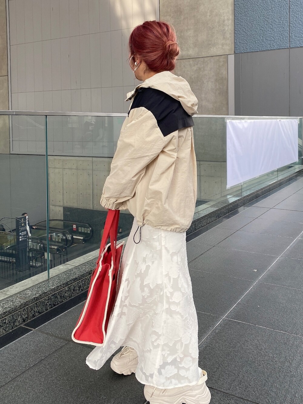 ホワイト系のスカート、ベージュ系のマウンテンパーカー、ホワイト系のニット/セーターを着用したレディースの春コーディネートの3枚目の写真