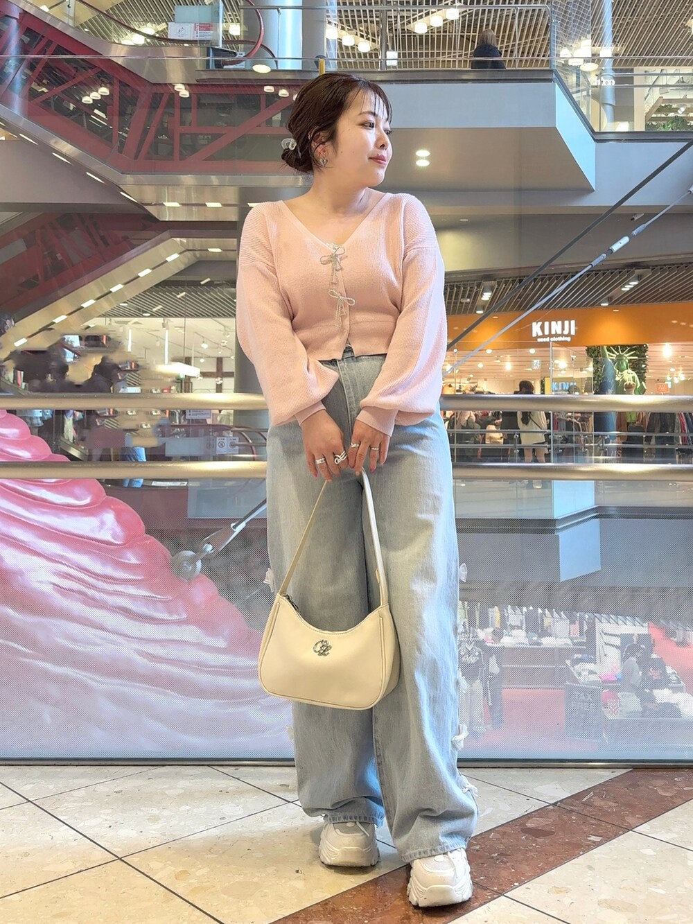 ベージュ系のトレンチコート、ピンク系のカーディガン/ボレロ、ホワイト系のショルダーバッグを着用したレディースの春コーディネートの3枚目の写真