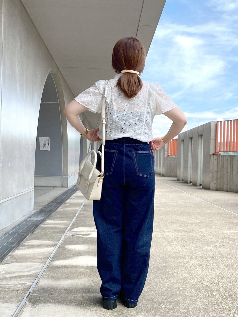 ホワイト系のシャツ/ブラウス、ブルー系のデニムパンツ、ホワイト系のショルダーバッグを着用したレディースの夏コーディネートの3枚目の写真